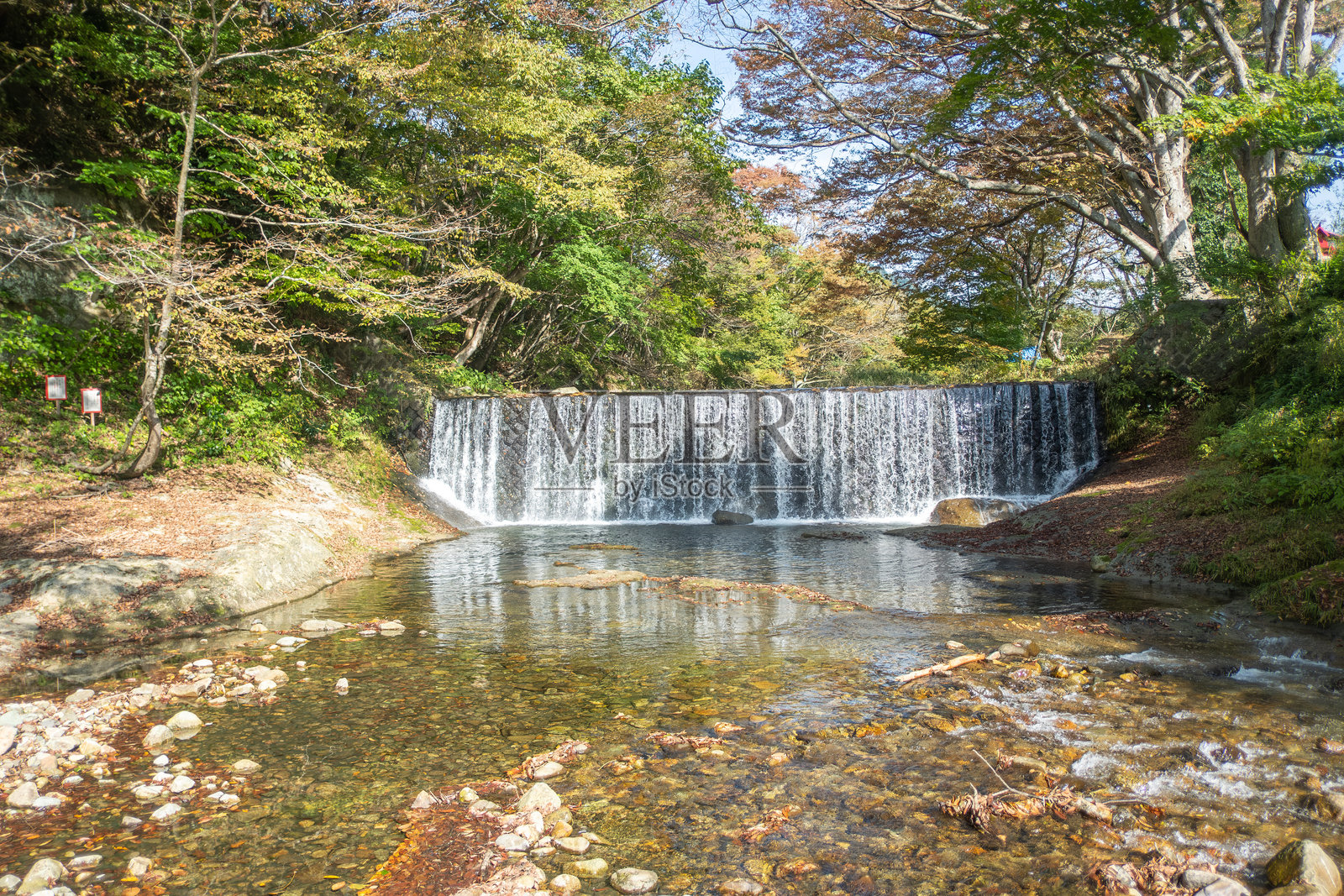 日本山形的山寺。宁静的瀑布倾泻入被树木环绕的岩石溪流中。照片摄影图片