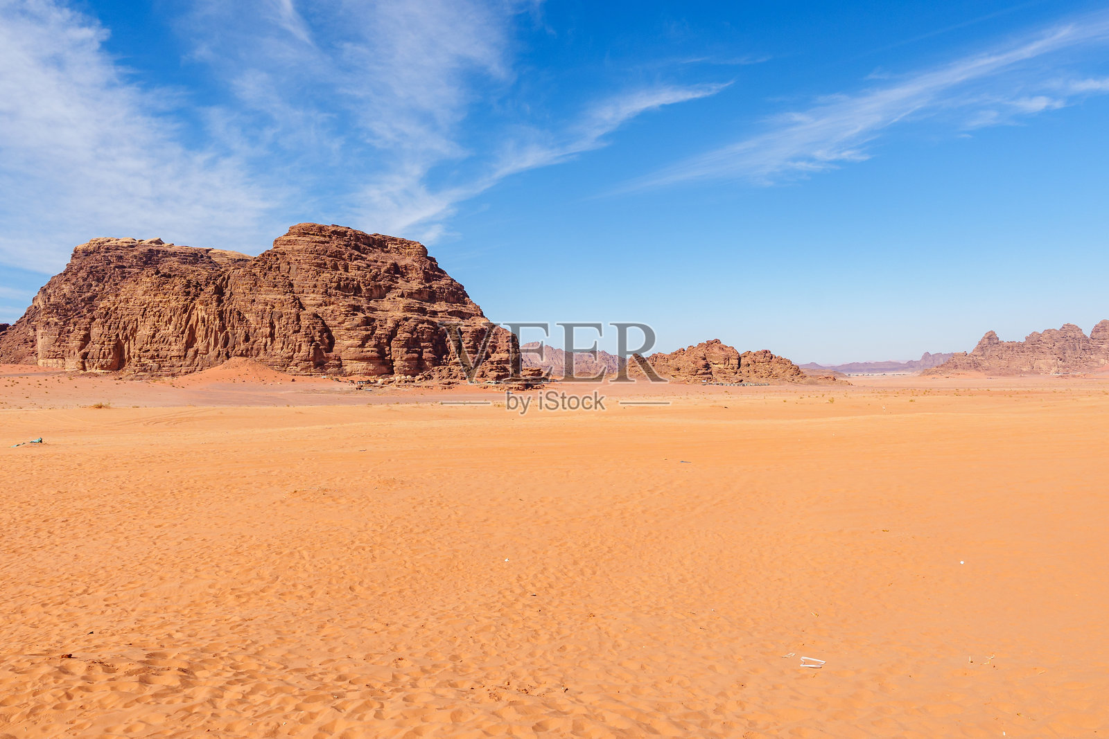约旦瓦迪拉姆沙漠的美丽景色。蓝天和轻柔云朵下的岩石地貌。照片摄影图片