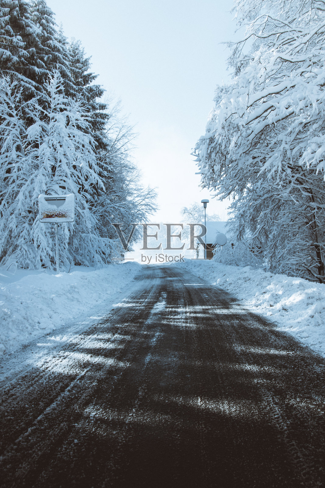 巴伐利亚森林冬季的道路，树木和道路上覆盖着厚厚的雪。照片摄影图片