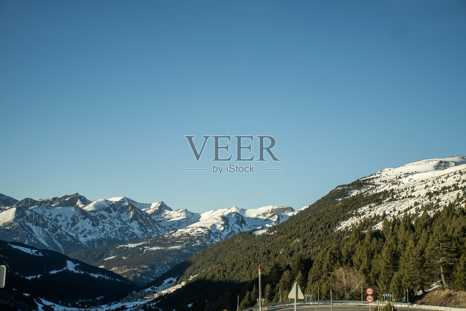 安道尔比利牛斯山顶的山路下坡，弯道上的交通标志照片摄影图片