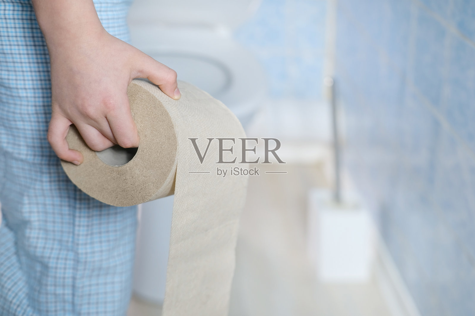 小男孩学习卫生规则，手里拿着卫生纸卷，孩子掌握如厕训练技能，特殊的家庭时刻照片摄影图片