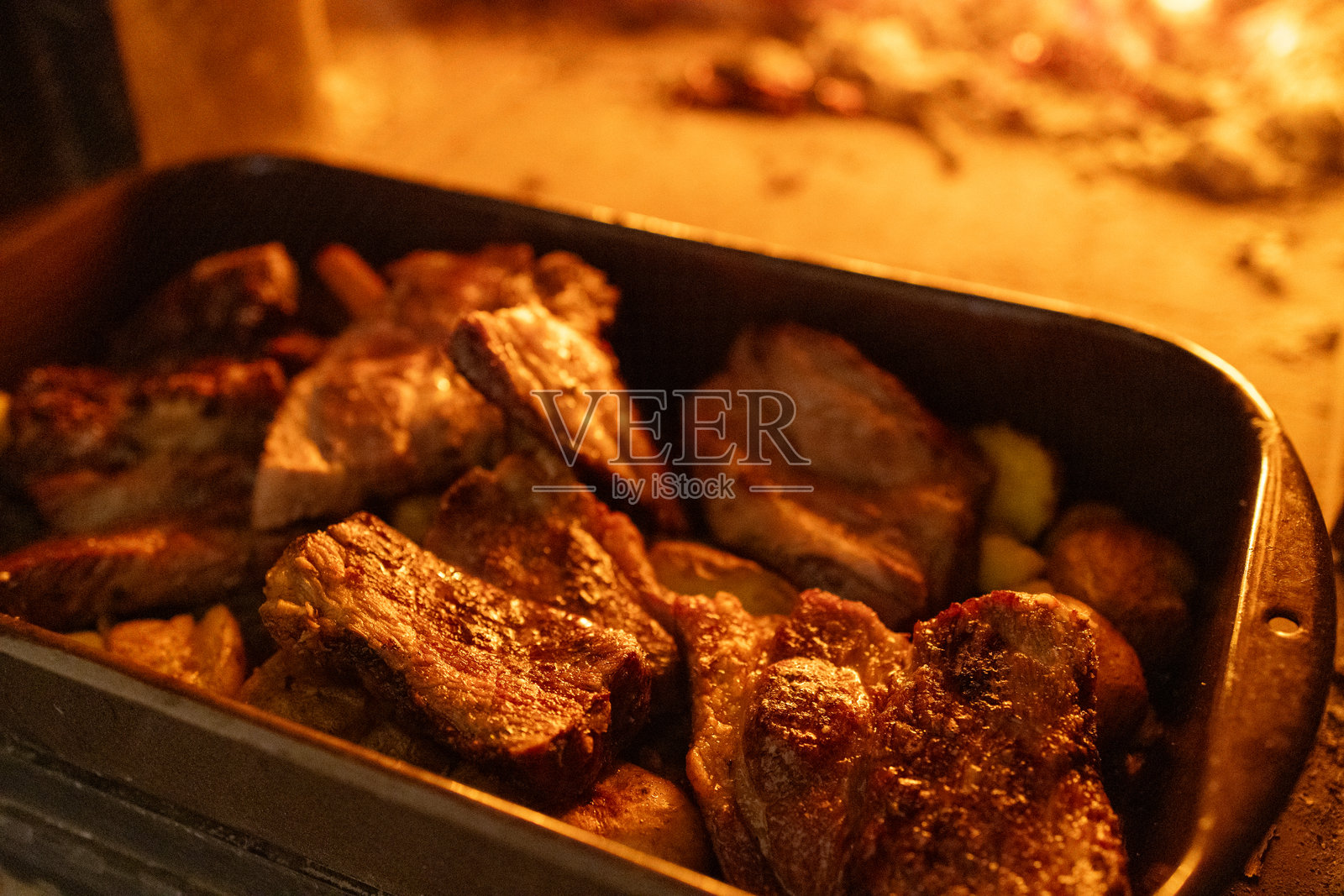 木火烤箱内托盘中的金棕色烤肉照片摄影图片