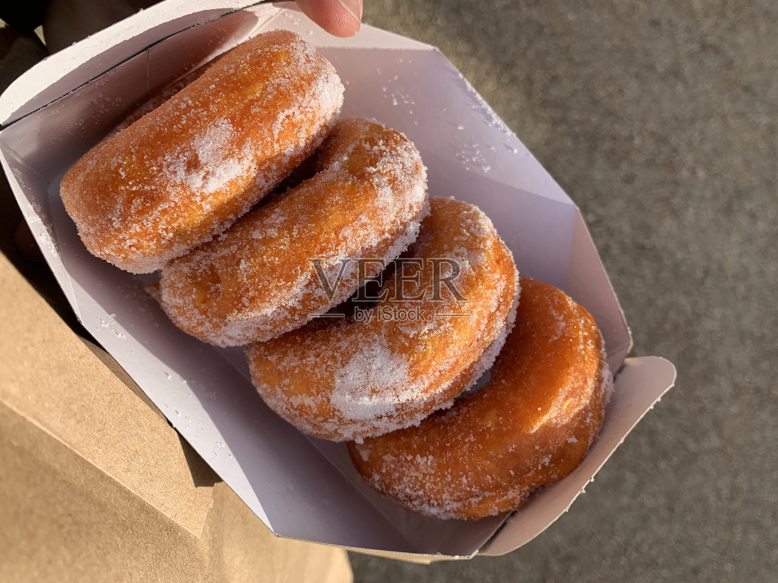 四个新鲜糖霜甜甜圈装在纸箱里照片摄影图片