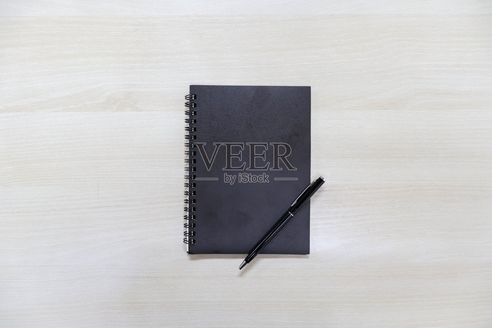 黑色封面笔记本和钢笔放在木桌背景上照片摄影图片