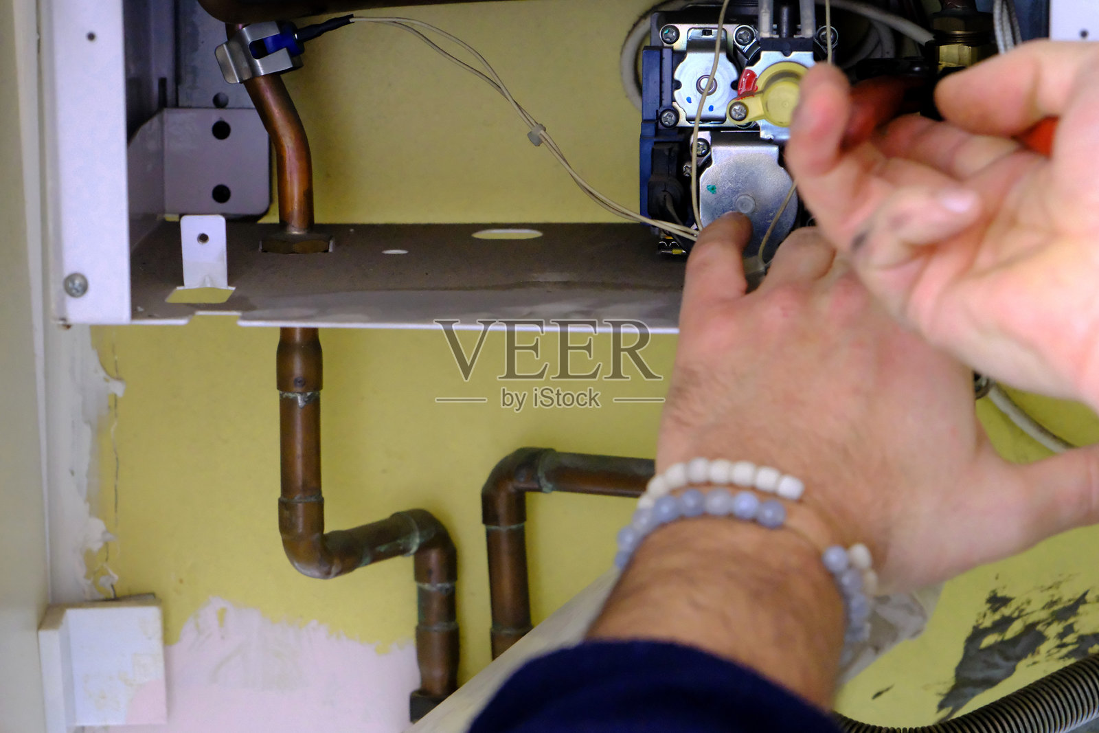 房屋内损坏的组合锅炉及维修工的维护和修理工作照片摄影图片