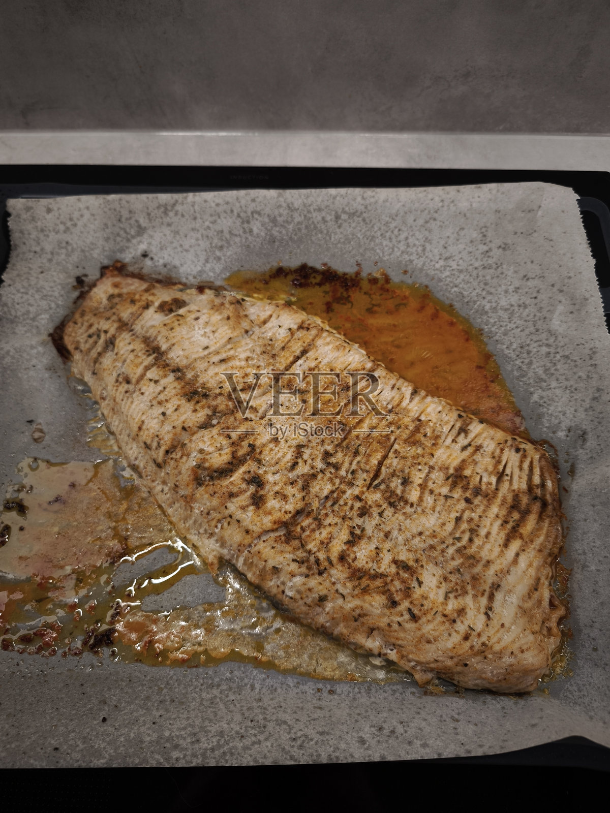 美味的烤鲤鱼片在烘焙纸上为圣诞晚餐烤制照片摄影图片