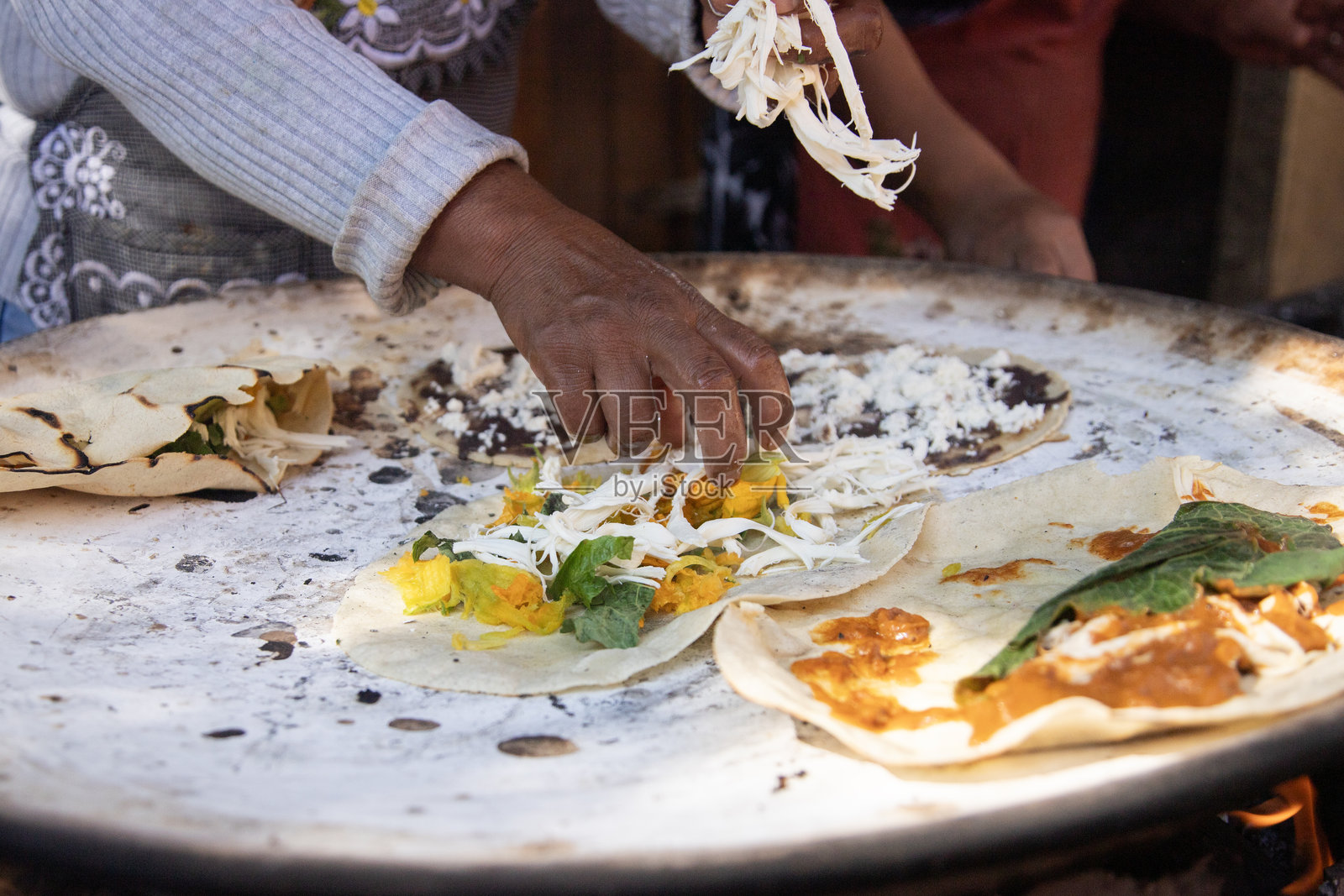 在墨西哥瓦哈卡地区的平底锅上烹饪传统的南瓜花玉米饼。照片摄影图片