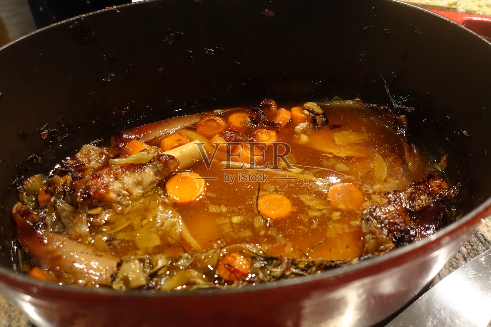 烤羊腿后，炖锅中盛放着肉汁、调味品、香草和蔬菜照片摄影图片
