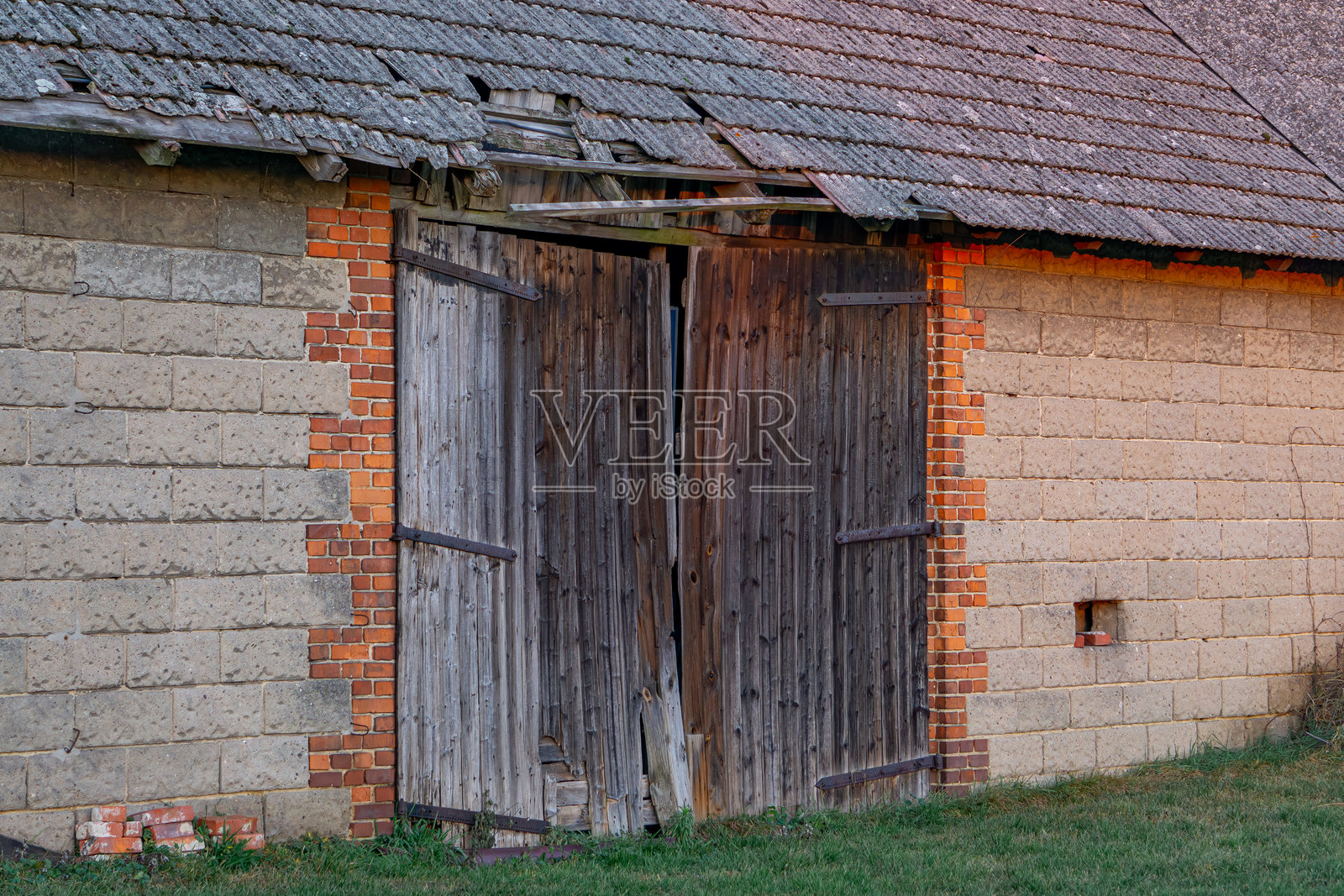 乡村老砖谷仓的木制大门和木栅栏。照片摄影图片