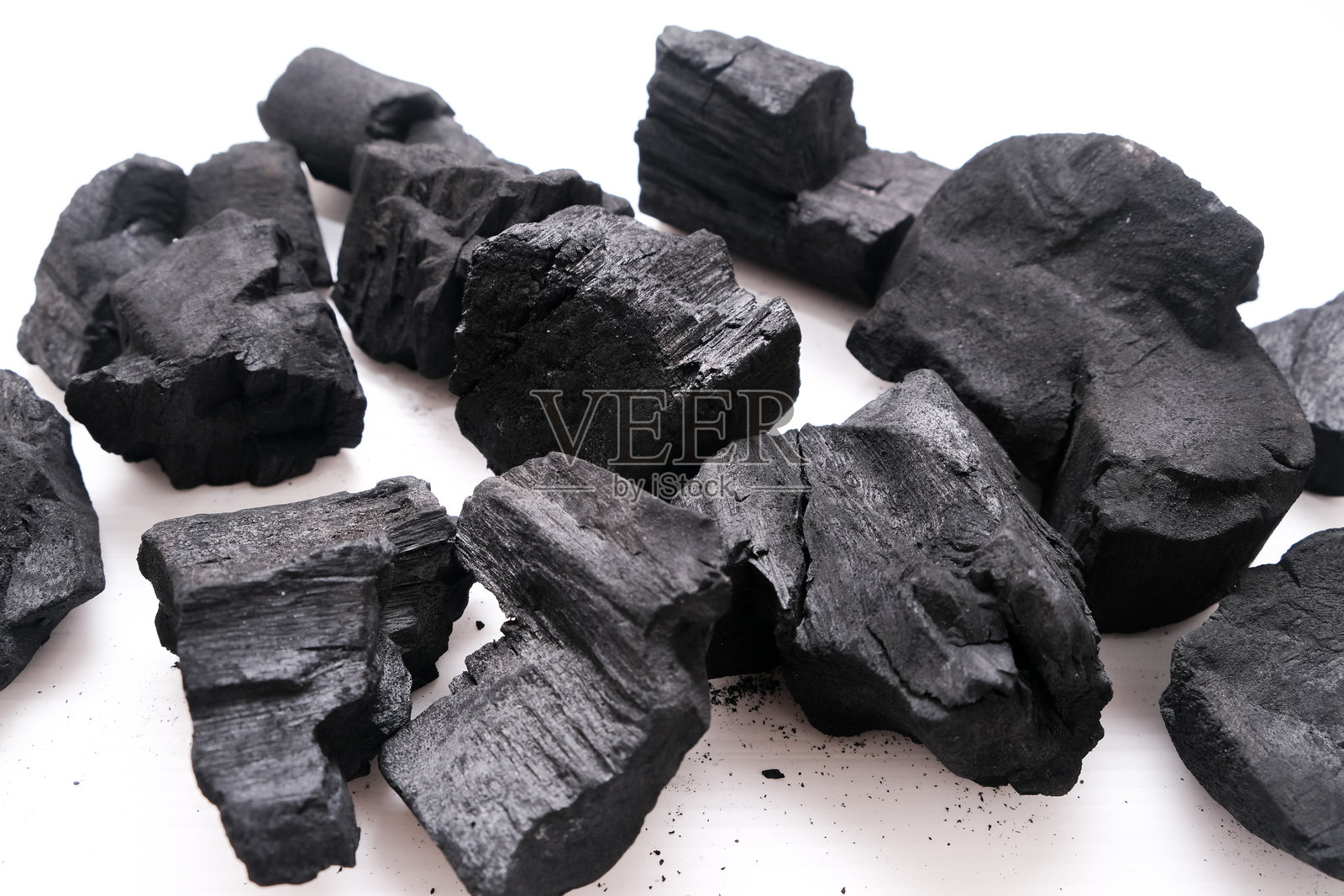 木炭。自然木炭、传统木炭或硬木炭的堆积，孤立在白色背景上。照片摄影图片