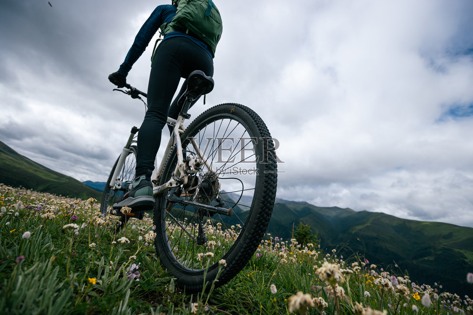 在草原山顶骑山地自行车照片摄影图片