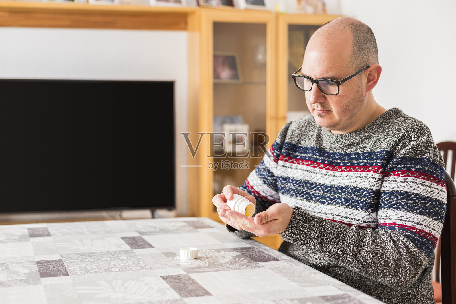 光头的白人男性正在准备，将药丸倒入手中照片摄影图片