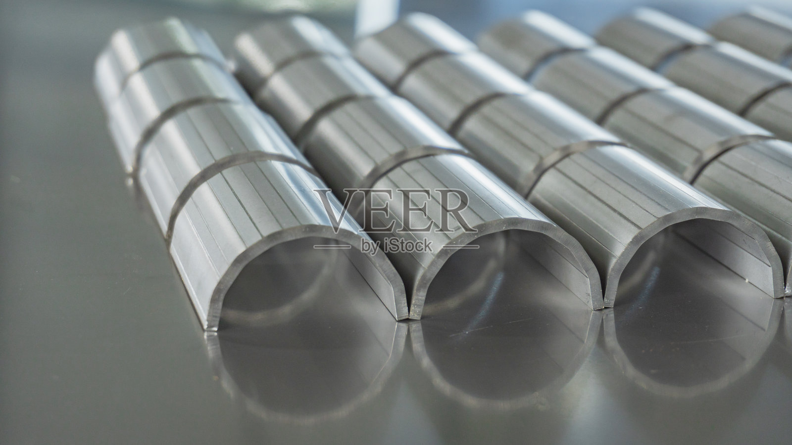 使用液压折弯机将不锈钢折叠成圆形。照片摄影图片