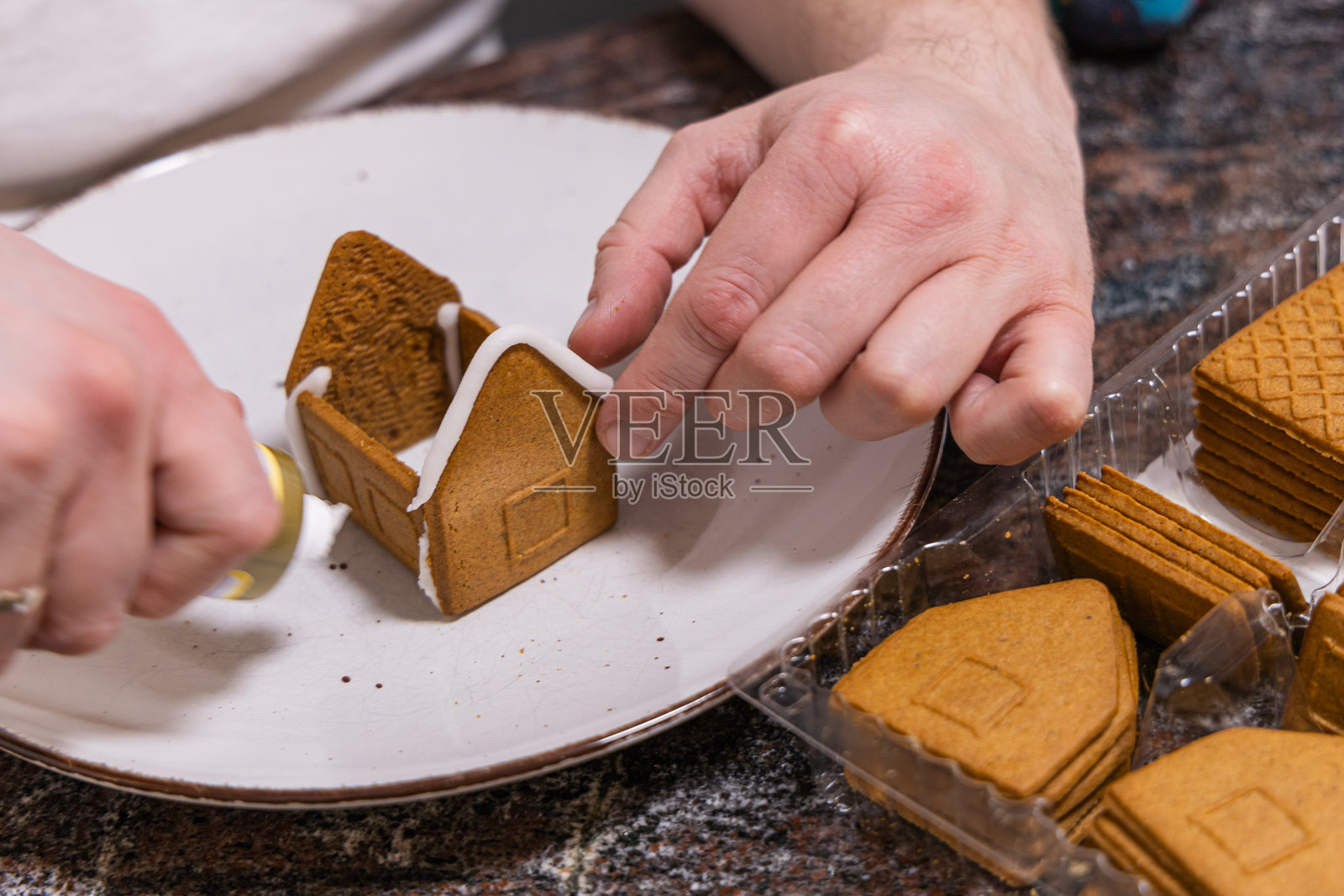 男人在制作圣诞姜饼，特写镜头。照片摄影图片
