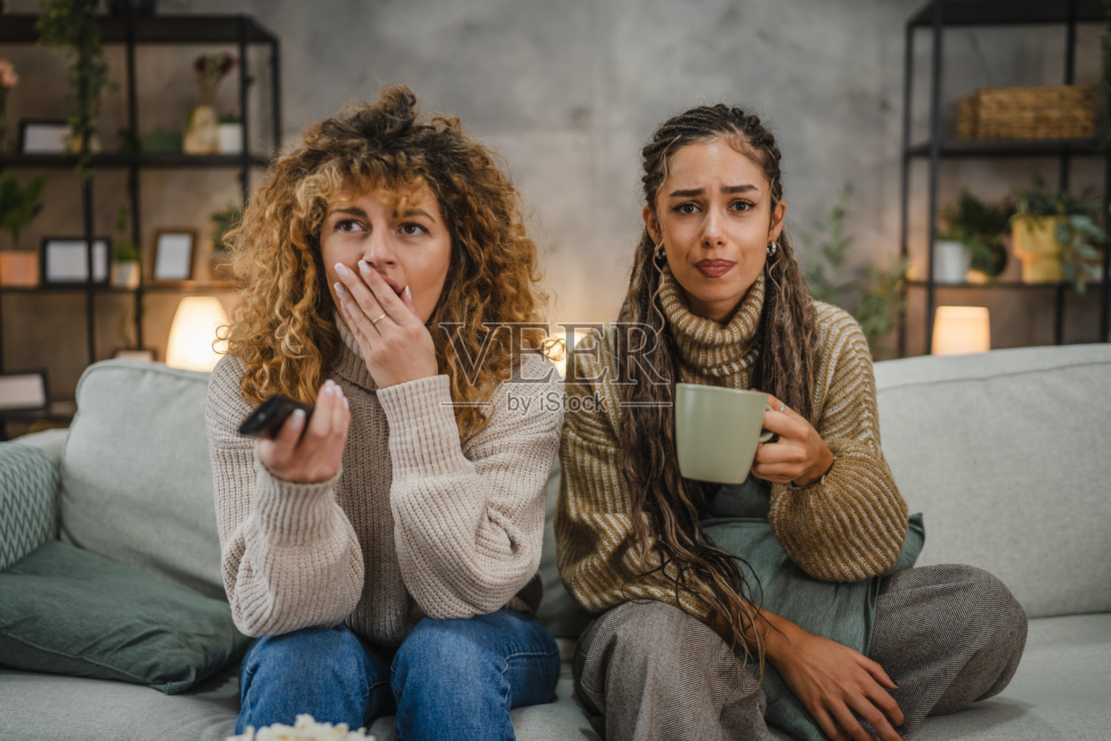 害怕的女性朋友们在家沙发上观看恐怖电影照片摄影图片
