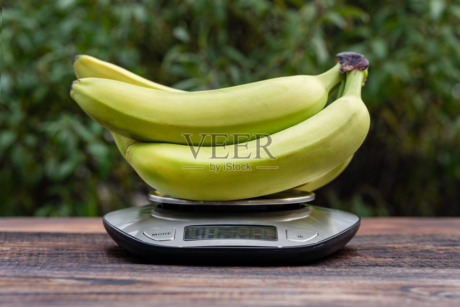 新鲜香蕉，木桌上的厨房秤照片摄影图片