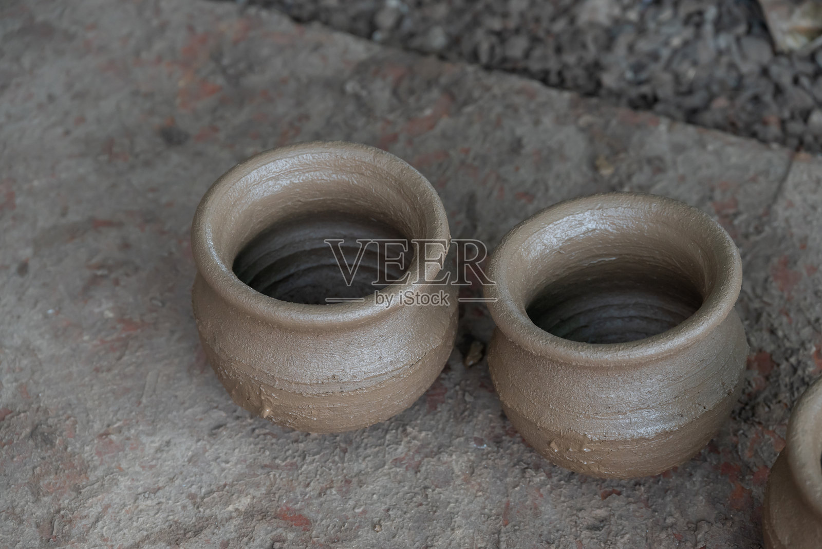 陶艺师在工作中，正在陶轮上制作陶瓷杯。照片摄影图片