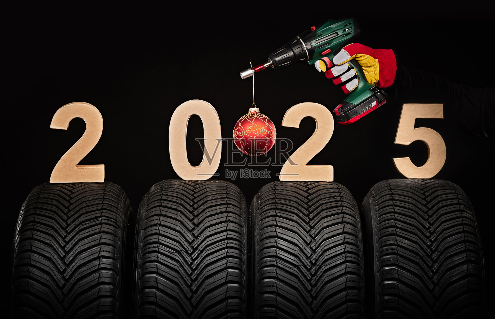 冬季汽车轮胎、大轮子服务和机械师手持扳手与圣诞球，2025新年黑色背景照片摄影图片