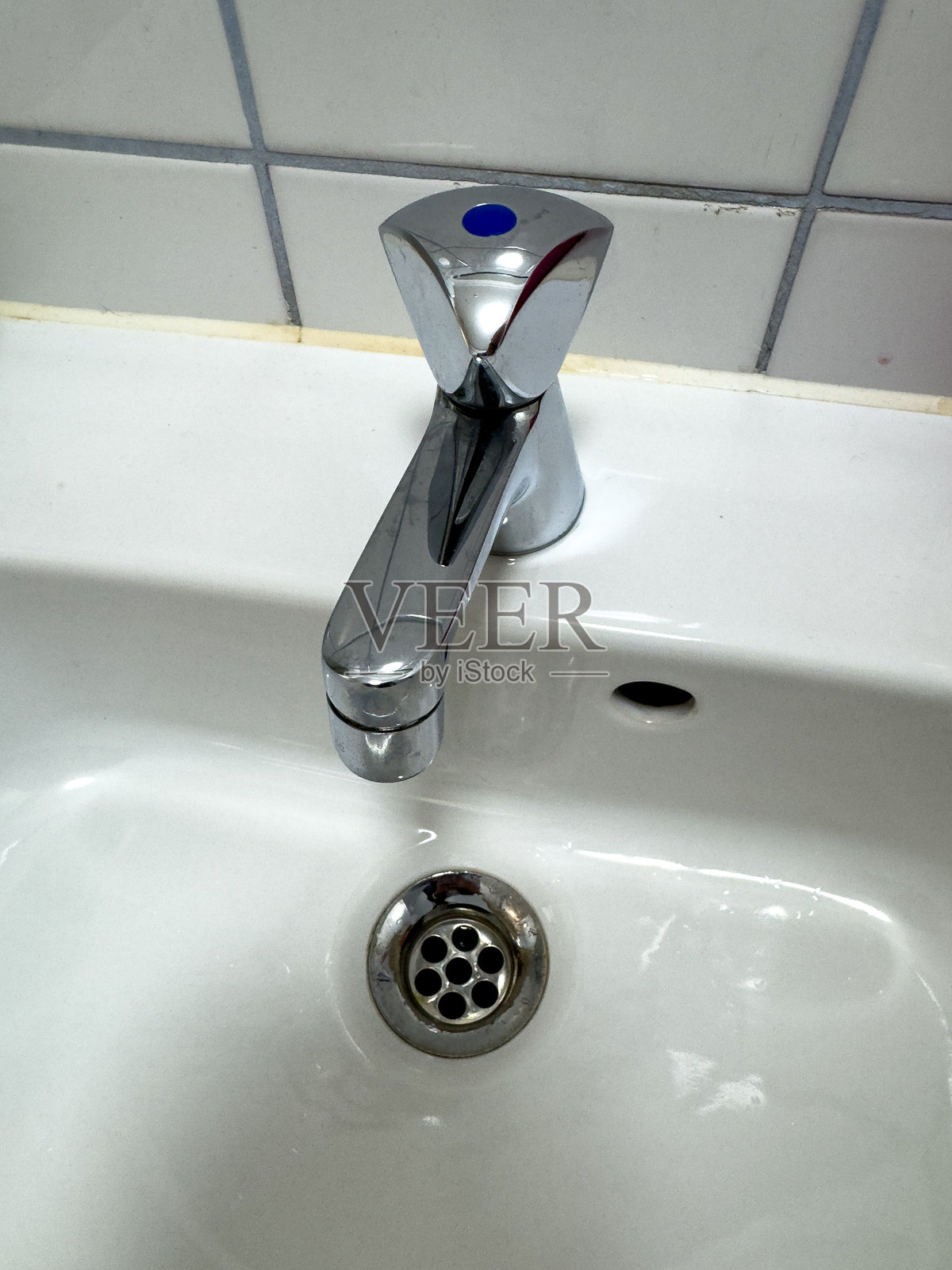 白色陶瓷洗手盆上的铬水龙头照片摄影图片