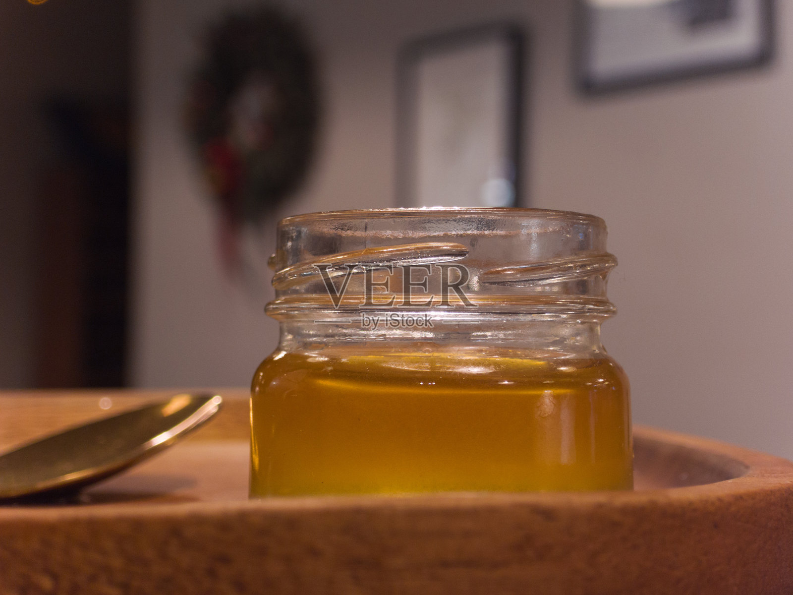 一个蜂蜜罐放在木托盘上照片摄影图片