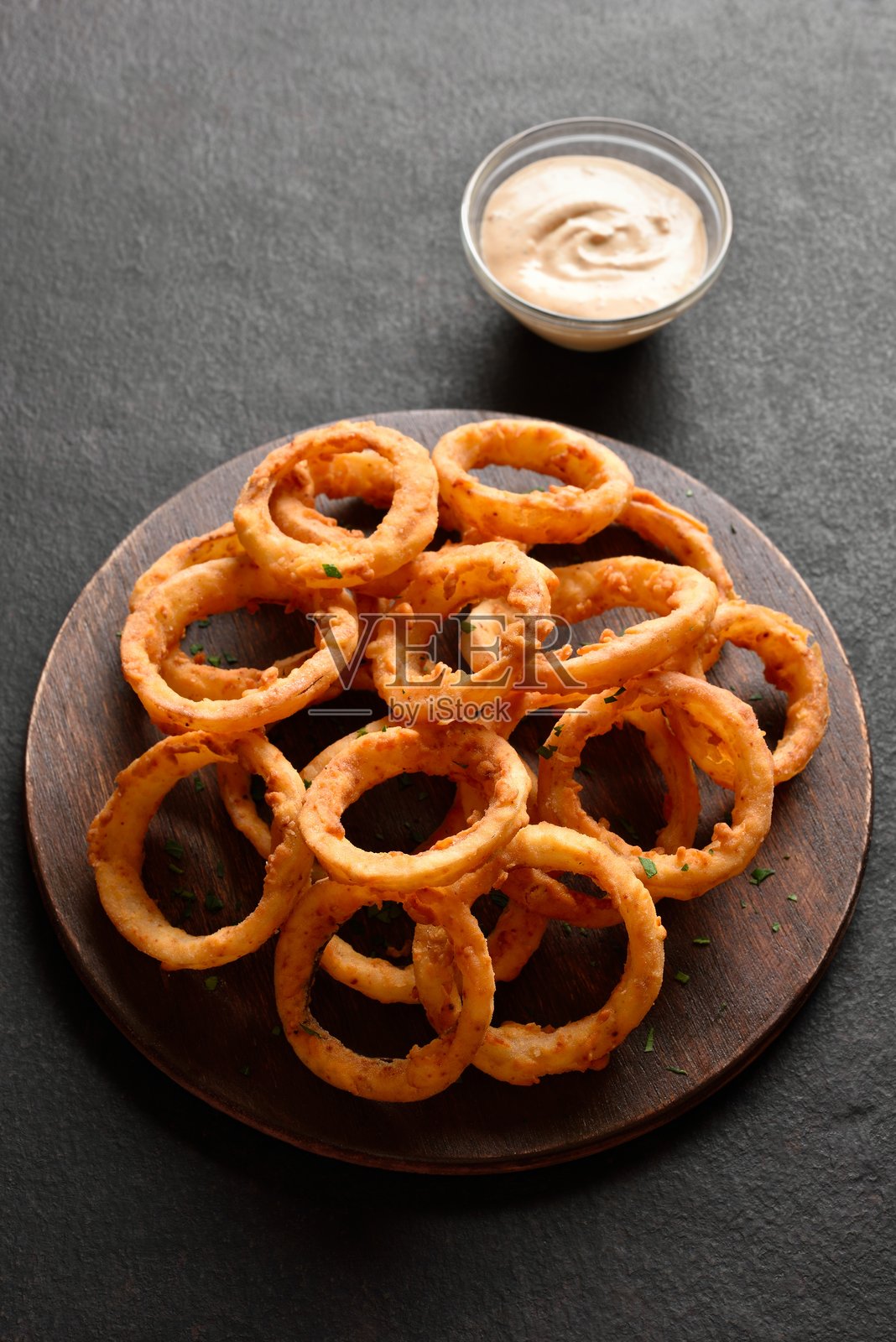 一堆炸洋葱圈放在木制托盘上照片摄影图片