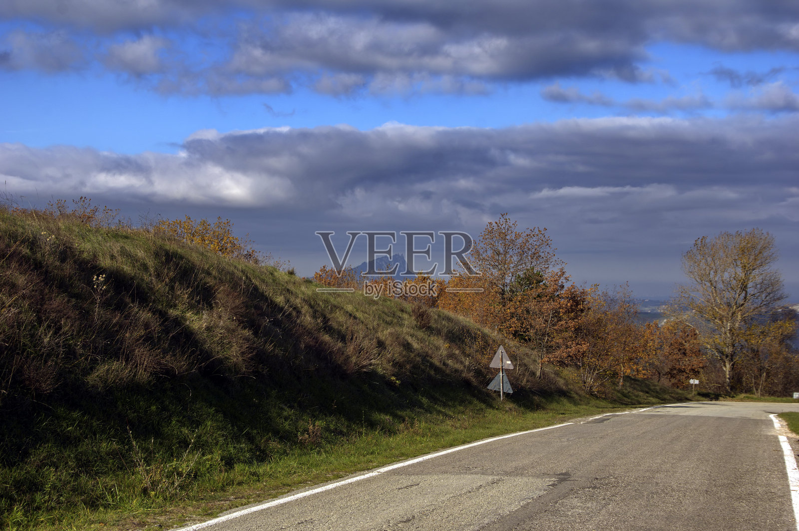 山丘上的沥青道路与多云的天空相映成趣照片摄影图片