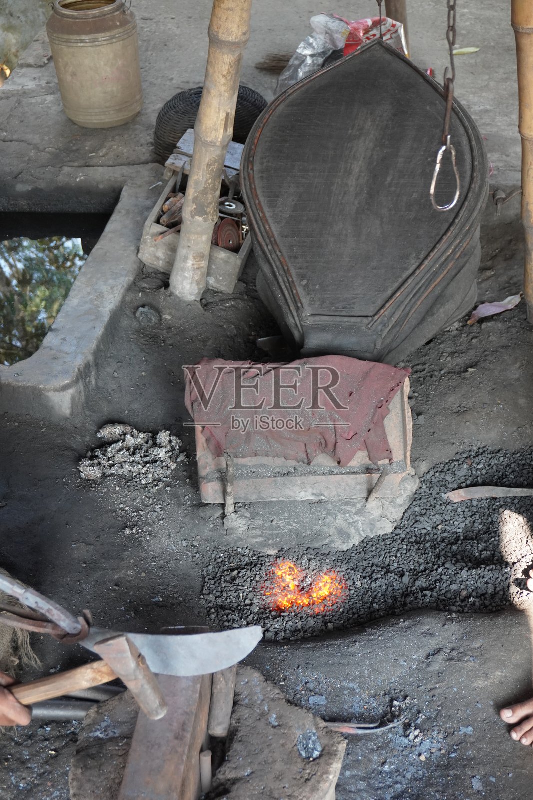 铁匠铺里火焰熊熊，锻炉位于铁匠铺旁边，为火提供空气以提高温度。照片摄影图片