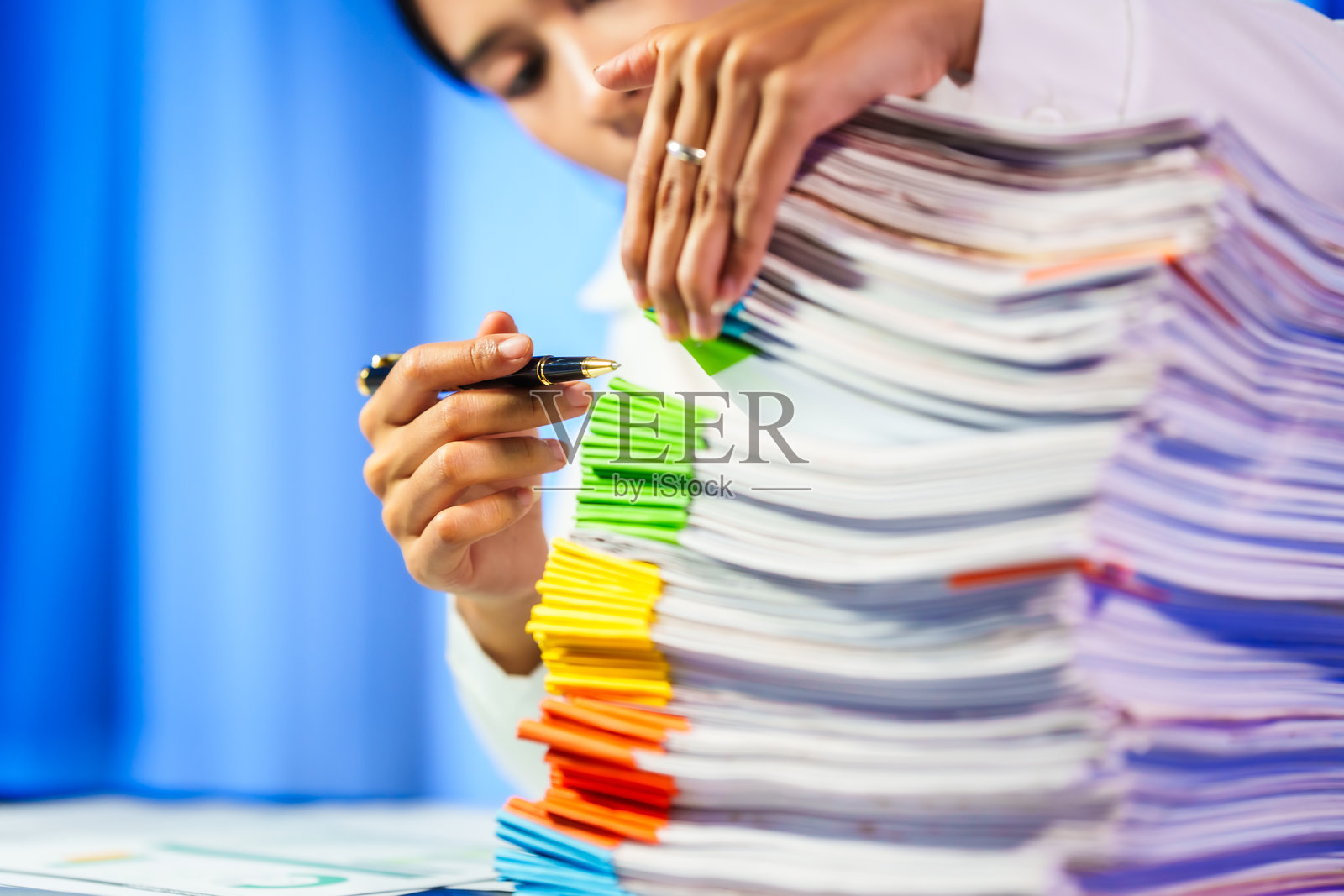 亚洲职业女性常常工作到深夜，承受着压力、头痛和偏头痛。长时间坐在办公桌前导致办公室综合症，造成颈部、肩部和背部疼痛。照片摄影图片