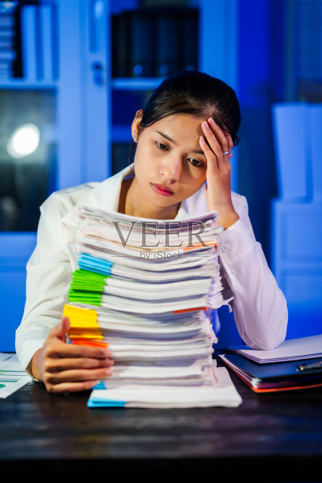 亚洲职业女性常常工作到深夜，承受着压力、头痛和偏头痛。长时间坐在办公桌前导致办公室综合症，进而引发颈部、肩部和背部疼痛。照片摄影图片