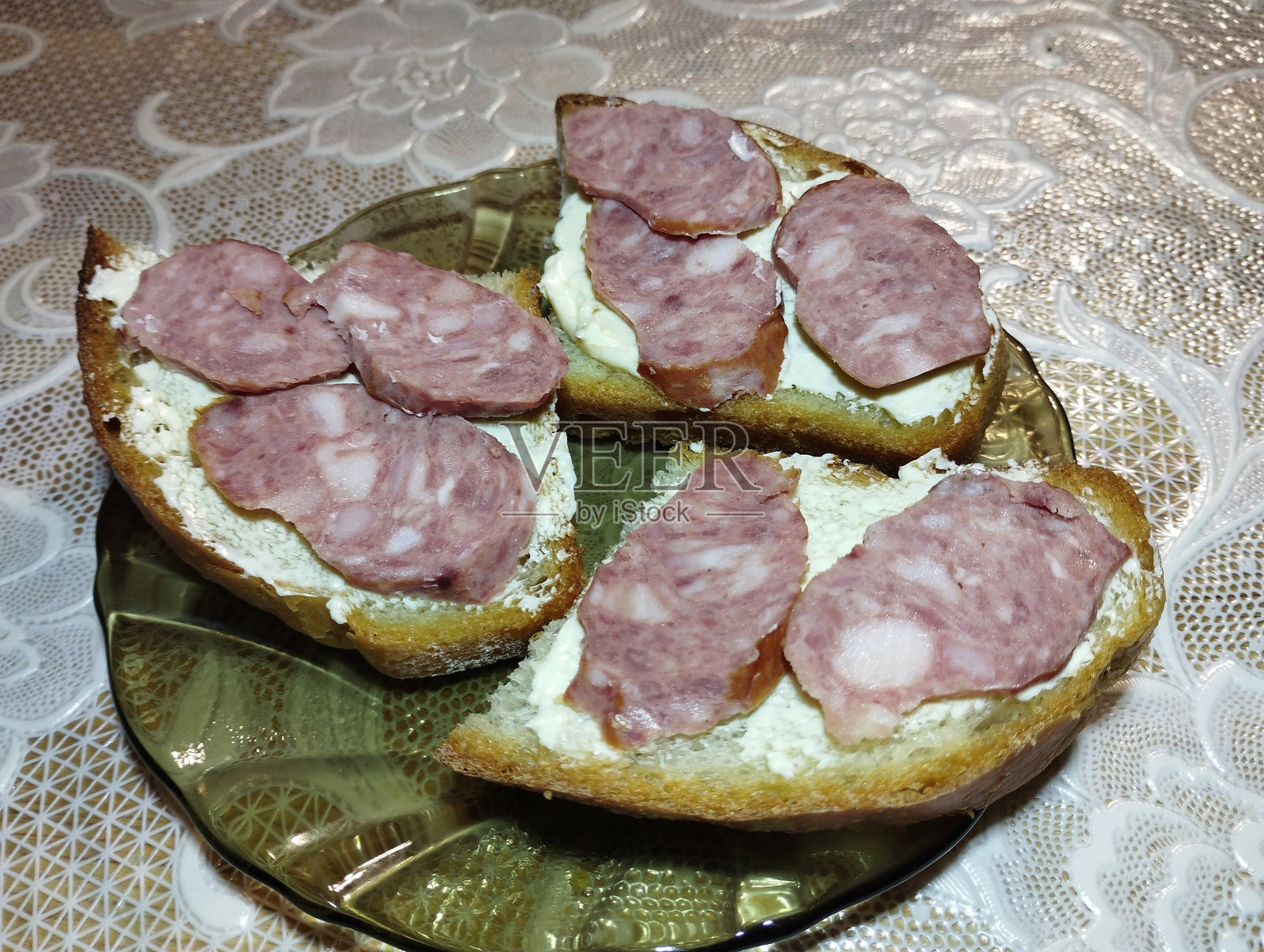 一盘面包、黄油和香肠的开胃小菜。早餐在桌上。照片摄影图片