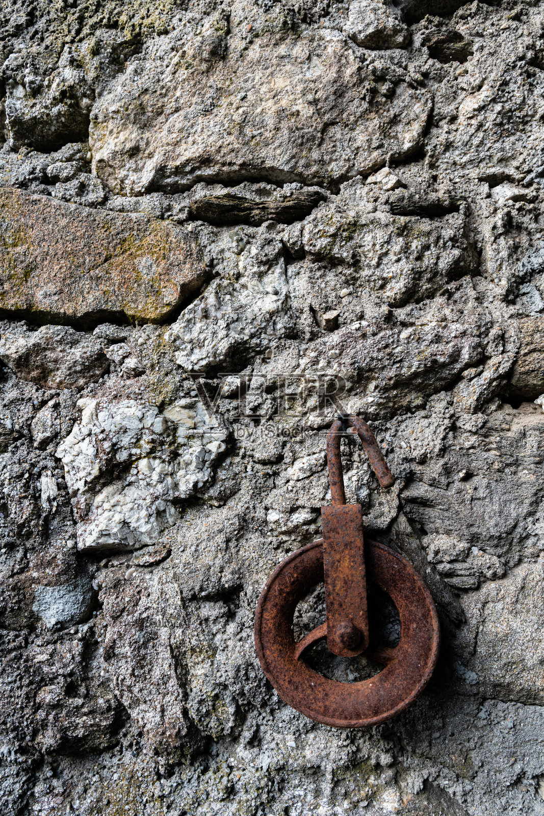 一只生锈的旧滑轮挂在墙上照片摄影图片