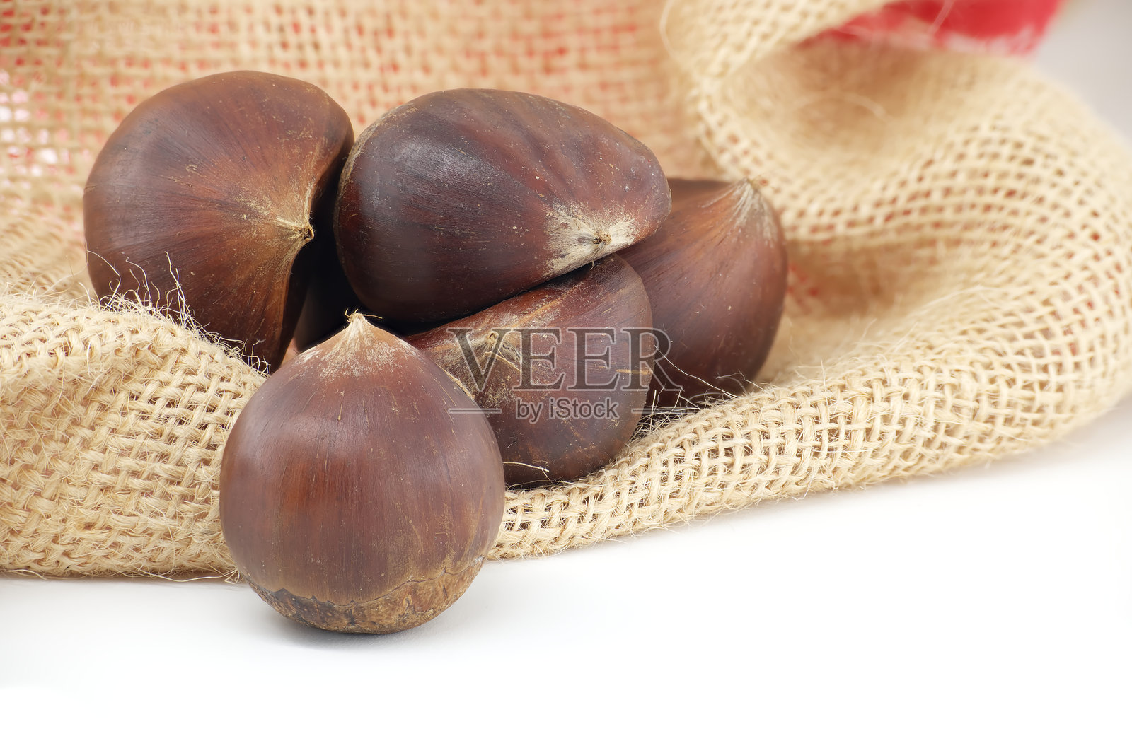 新鲜的栗子静静地放在麻布上，沐浴在柔和的自然光中照片摄影图片
