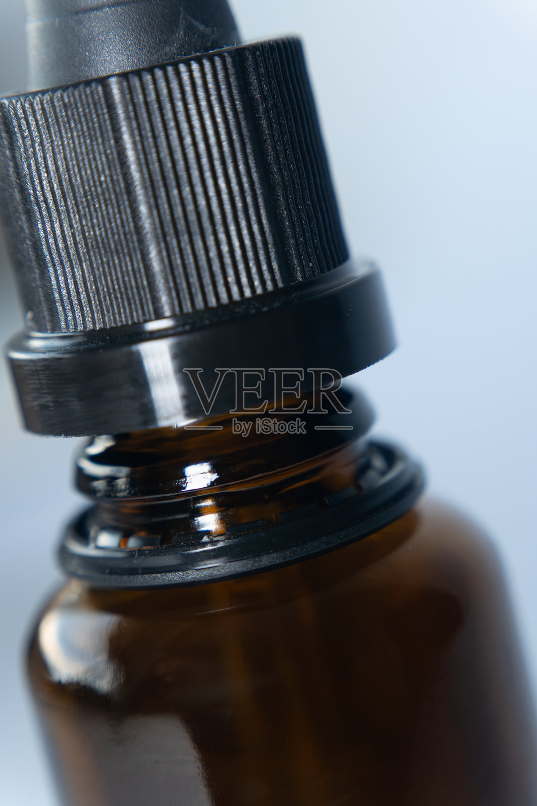 瓶颈：一只棕色玻璃瓶的顶部特写，展示了面部精华的简约设计和优质品质。照片摄影图片