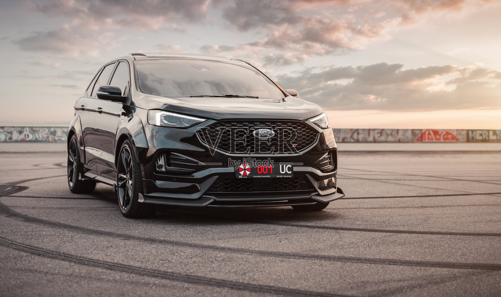 黑色福特Edge ST在日落时分的巨大停车场中。照片摄影图片