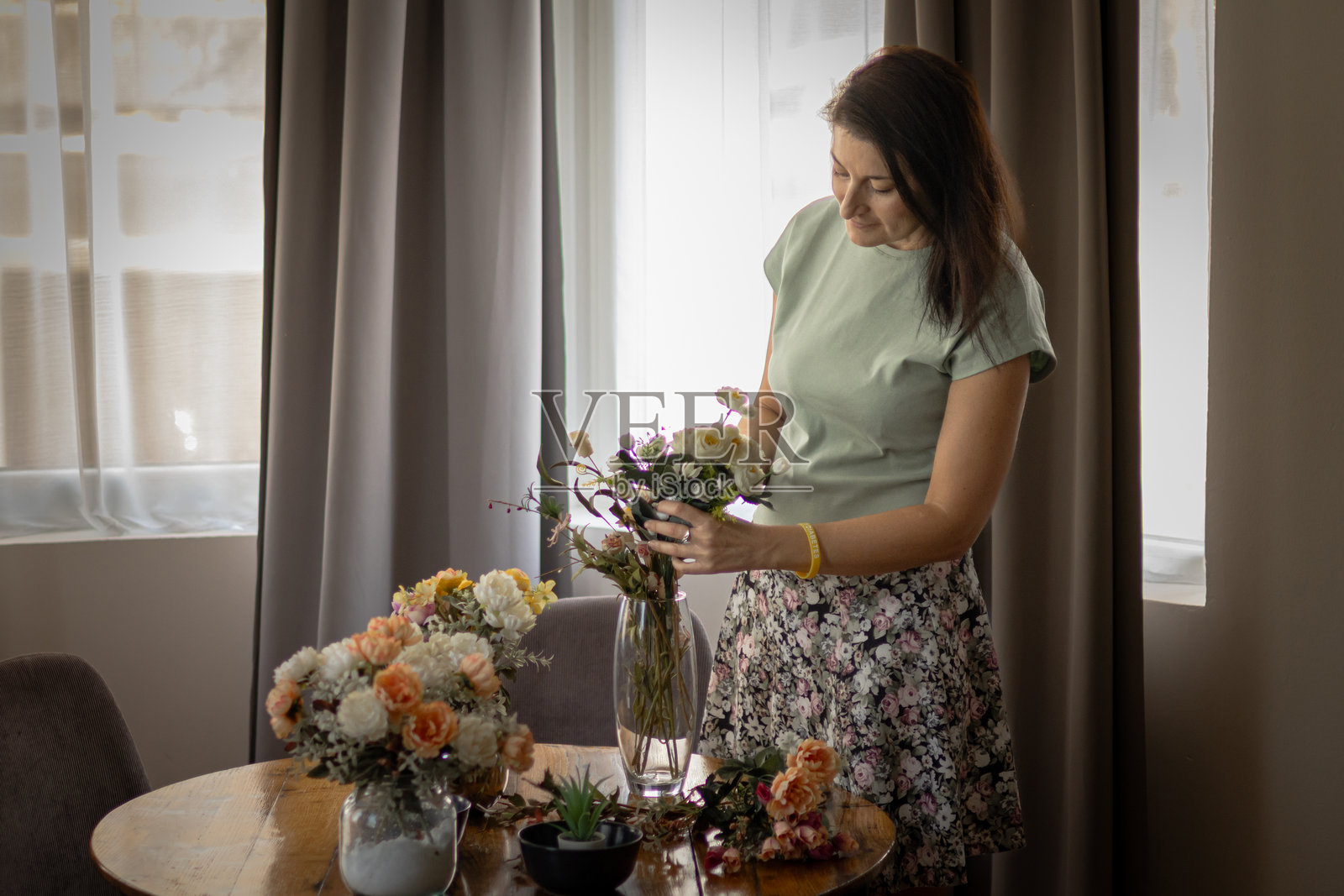 享受退休生活。爱好与手工艺。女性在家中享受插花，制作美丽的花束。照片摄影图片