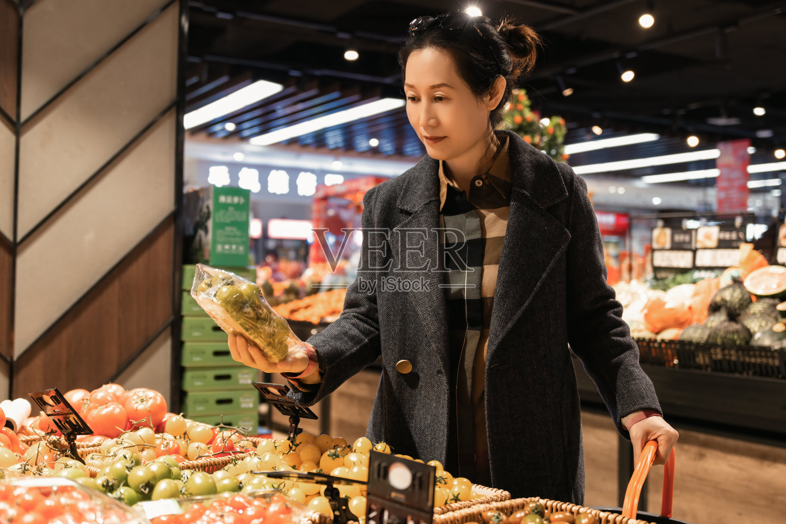 女性在现代超市挑选新鲜农产品照片摄影图片