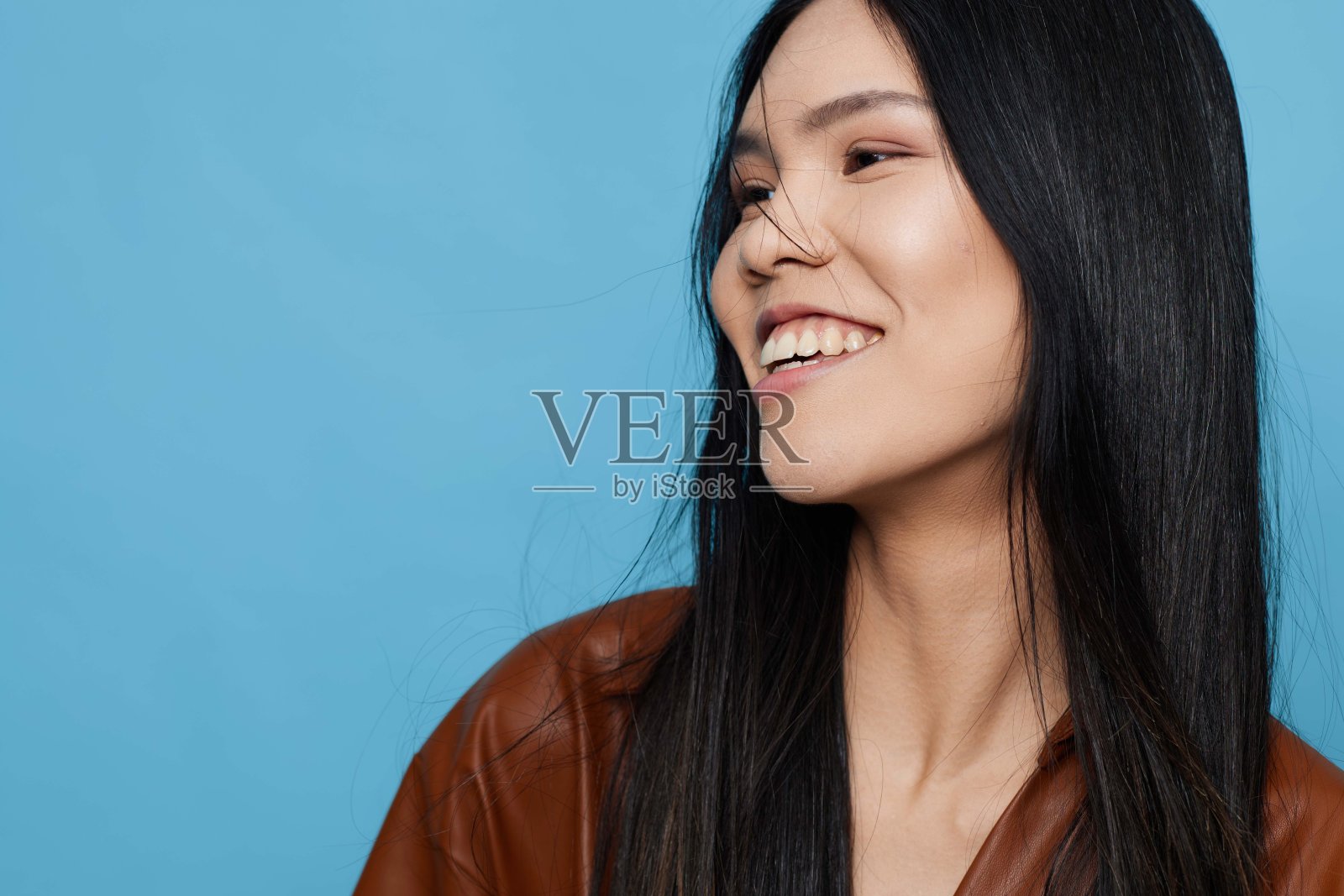 时尚蓝色背景下微笑的亚洲女孩吸引人的生活方式肖像照片摄影图片