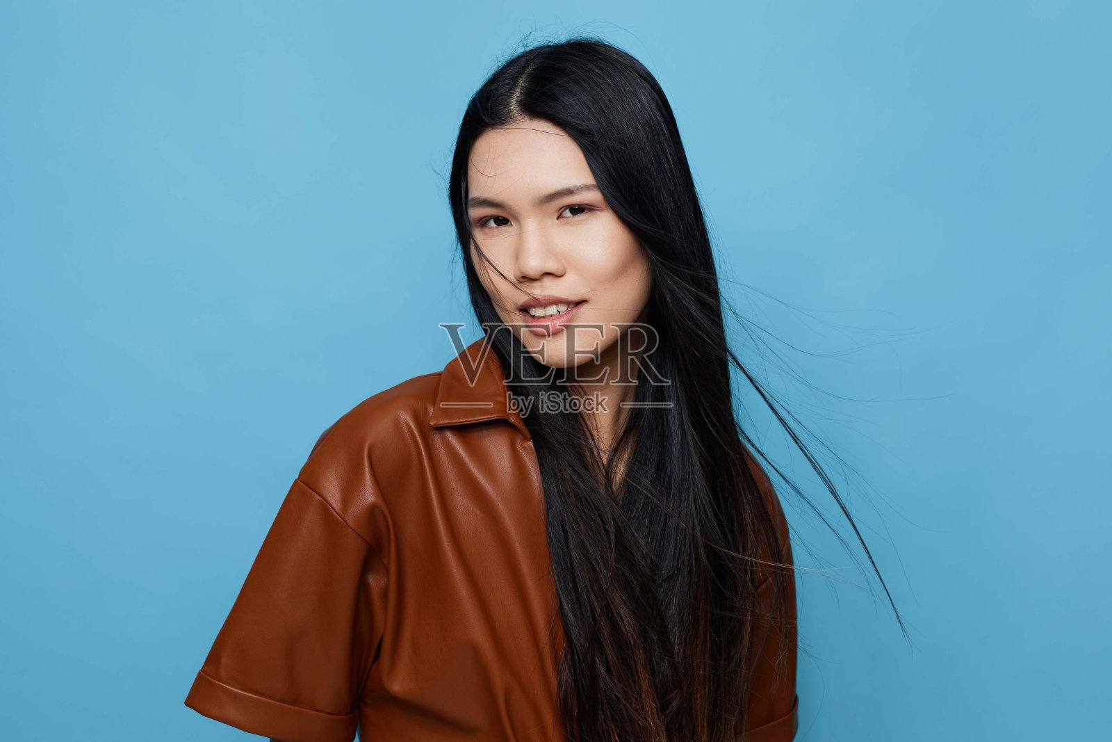 时尚的亚洲女孩在工作室中微笑，背景可爱而充满活力。照片摄影图片