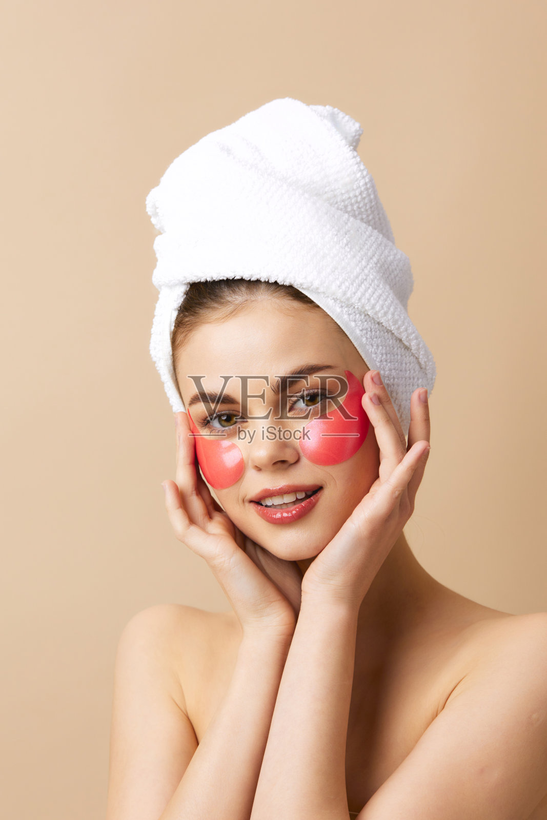 年轻女性头上裹着毛巾，手势表达护肤的特写生活方式照片摄影图片