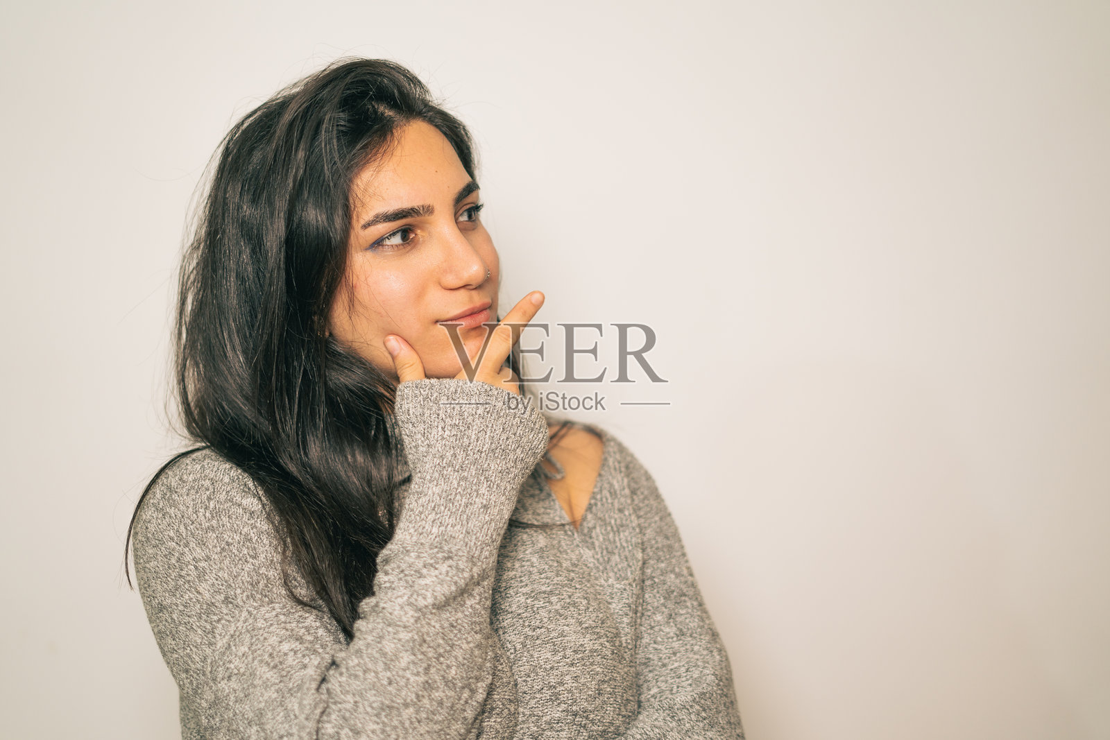 沉思的年轻女性以休闲姿势展现照片摄影图片