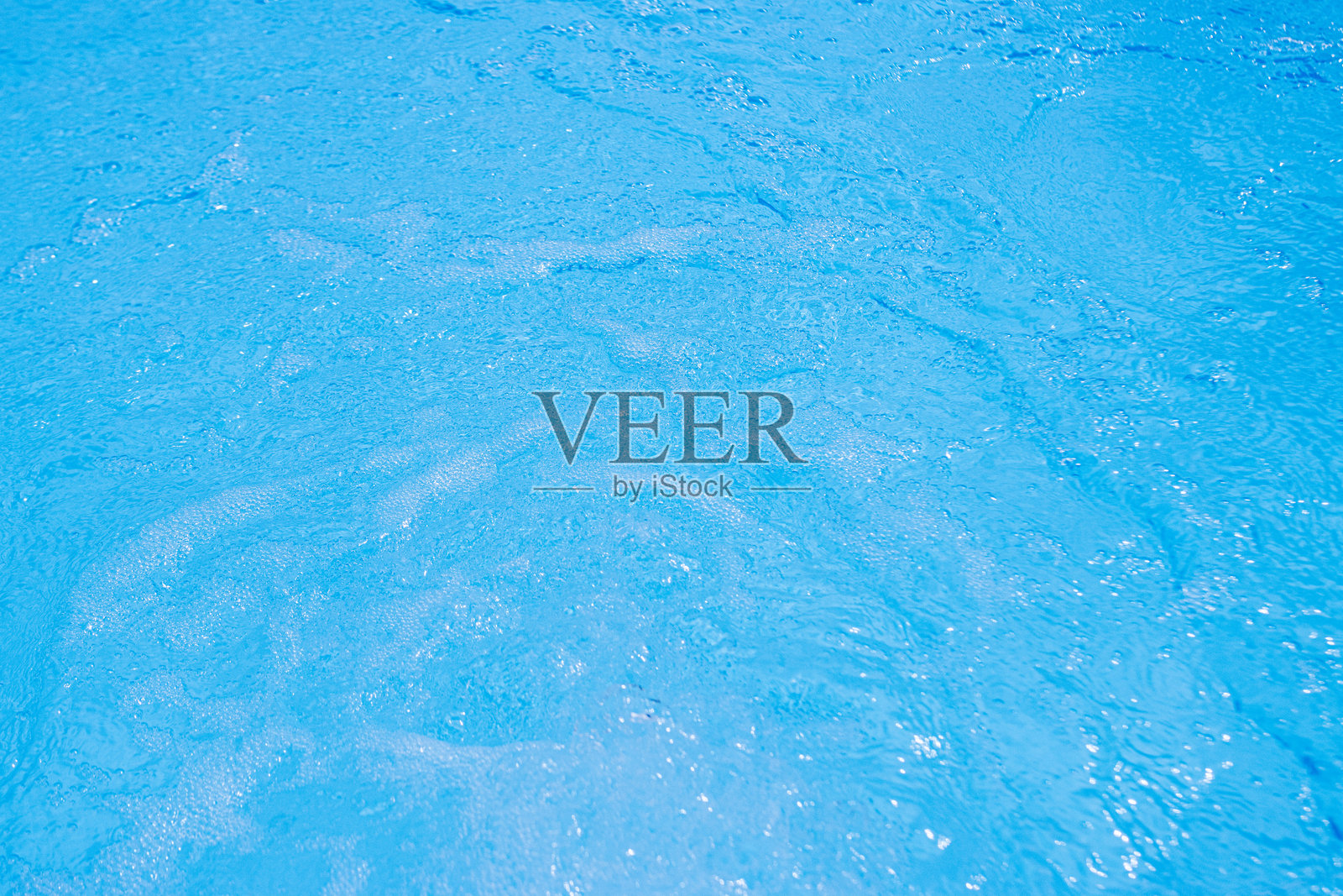 宁静的蓝色水面，轻柔的涟漪和柔和的阳光照耀照片摄影图片