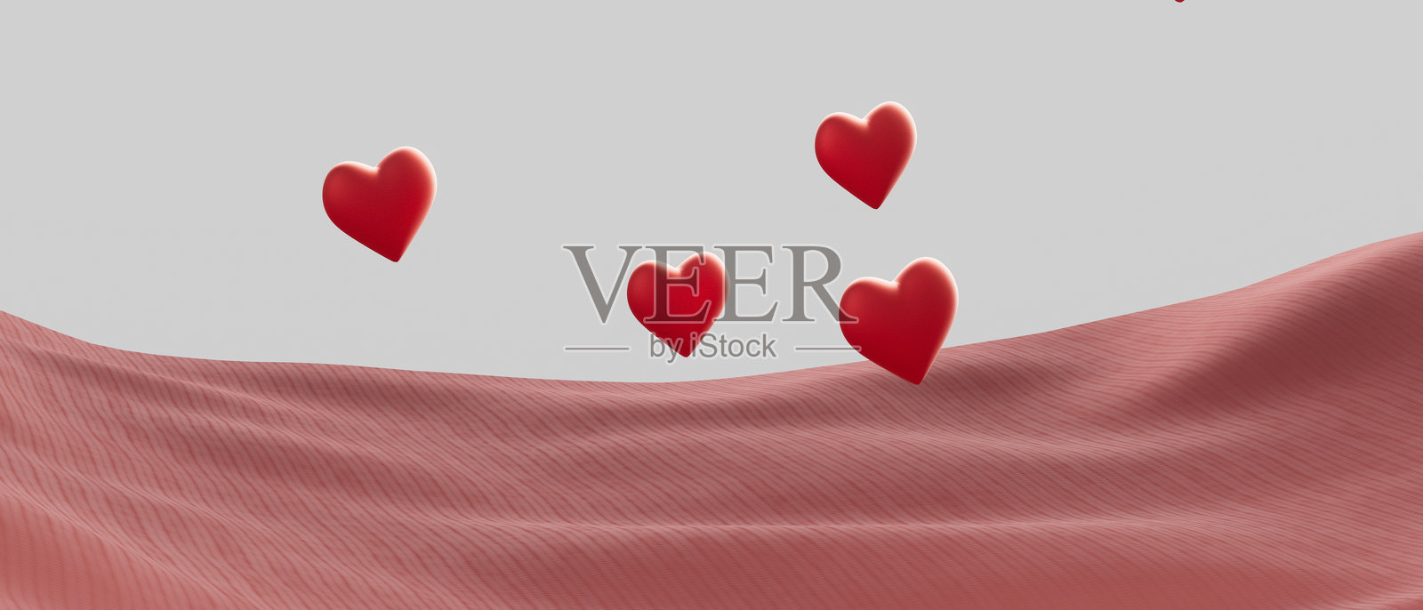 一块粉色布料的特写，上面有四个红色心形图案照片摄影图片