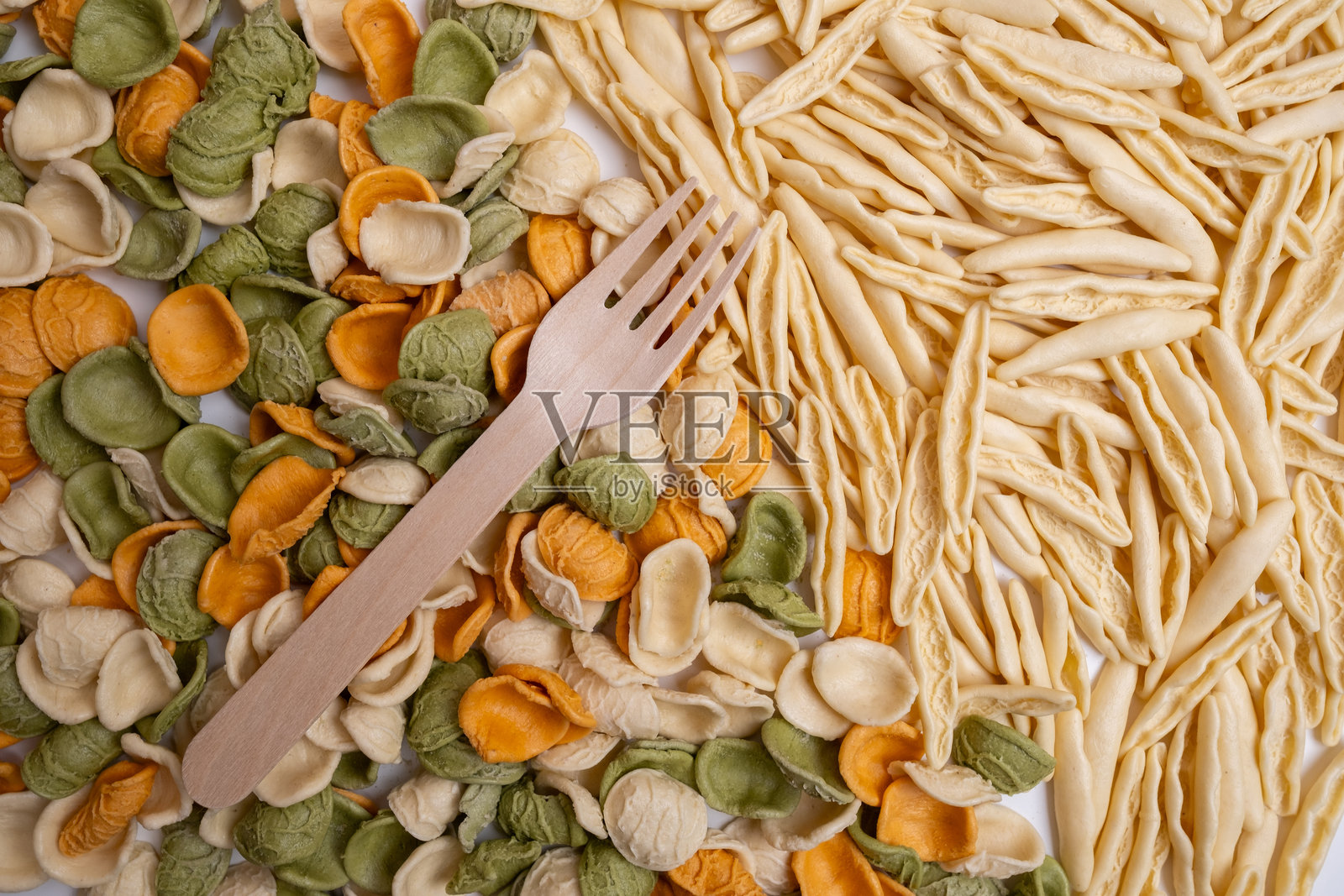 生意面背景特写。各种类型的意大利面和面条在彩色背景上。意大利美食烹饪概念。不同生意面的集合在烹饪桌上。照片摄影图片