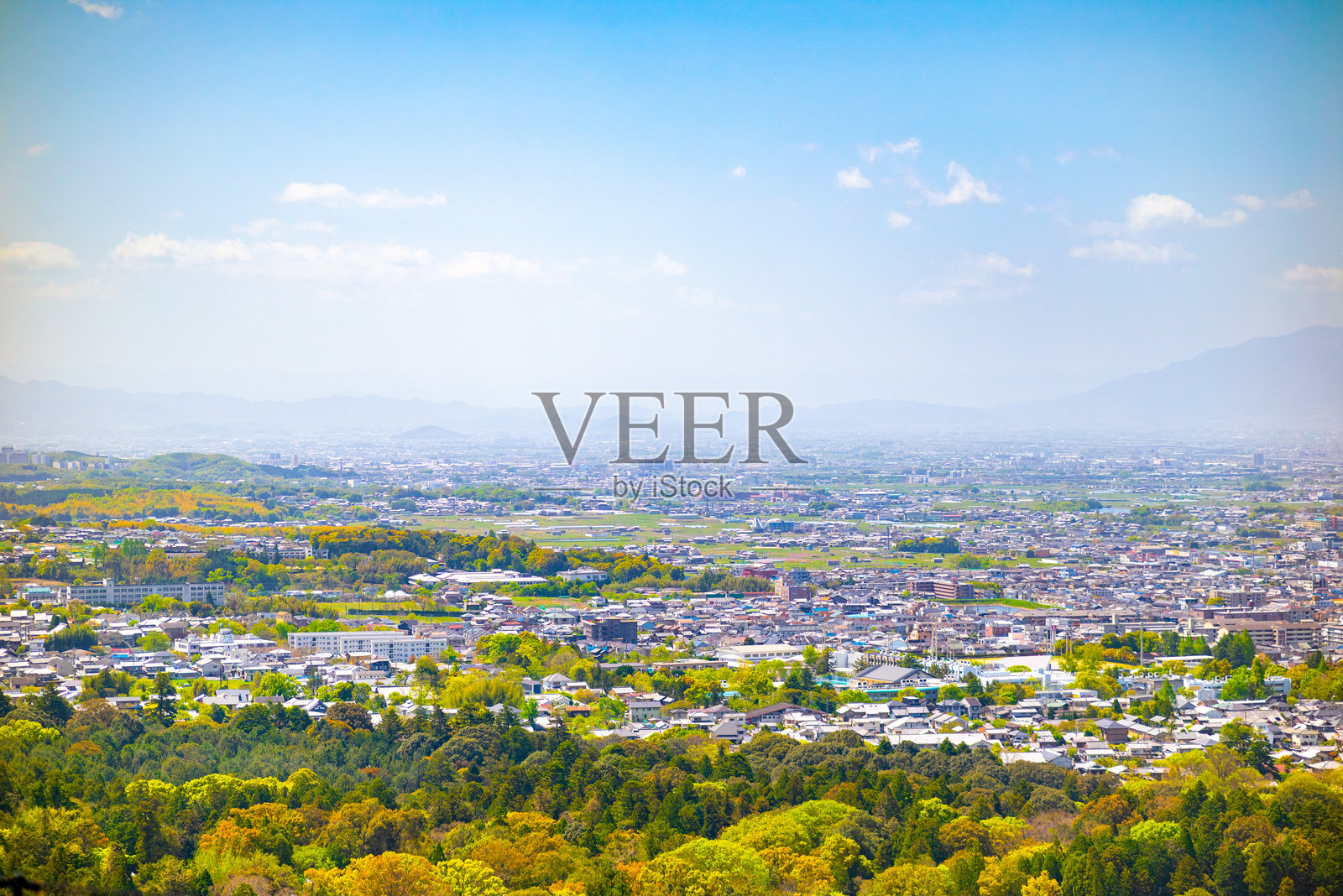 郁郁葱葱的城市景观与起伏的山丘的鸟瞰图照片摄影图片