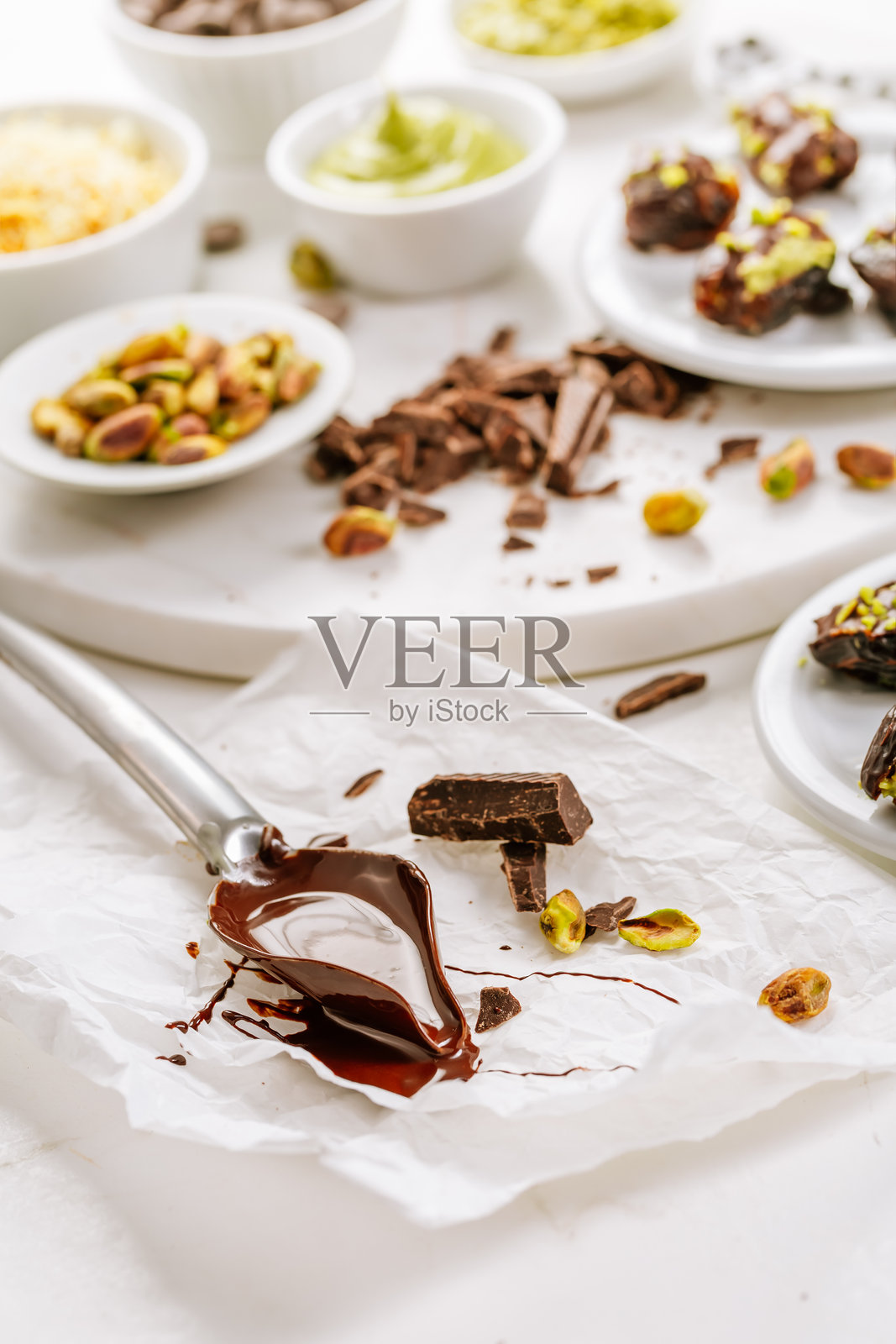 准备精致的甜点，椰枣填充开心果慕斯，作为流行的迪拜巧克力棒的替代品照片摄影图片