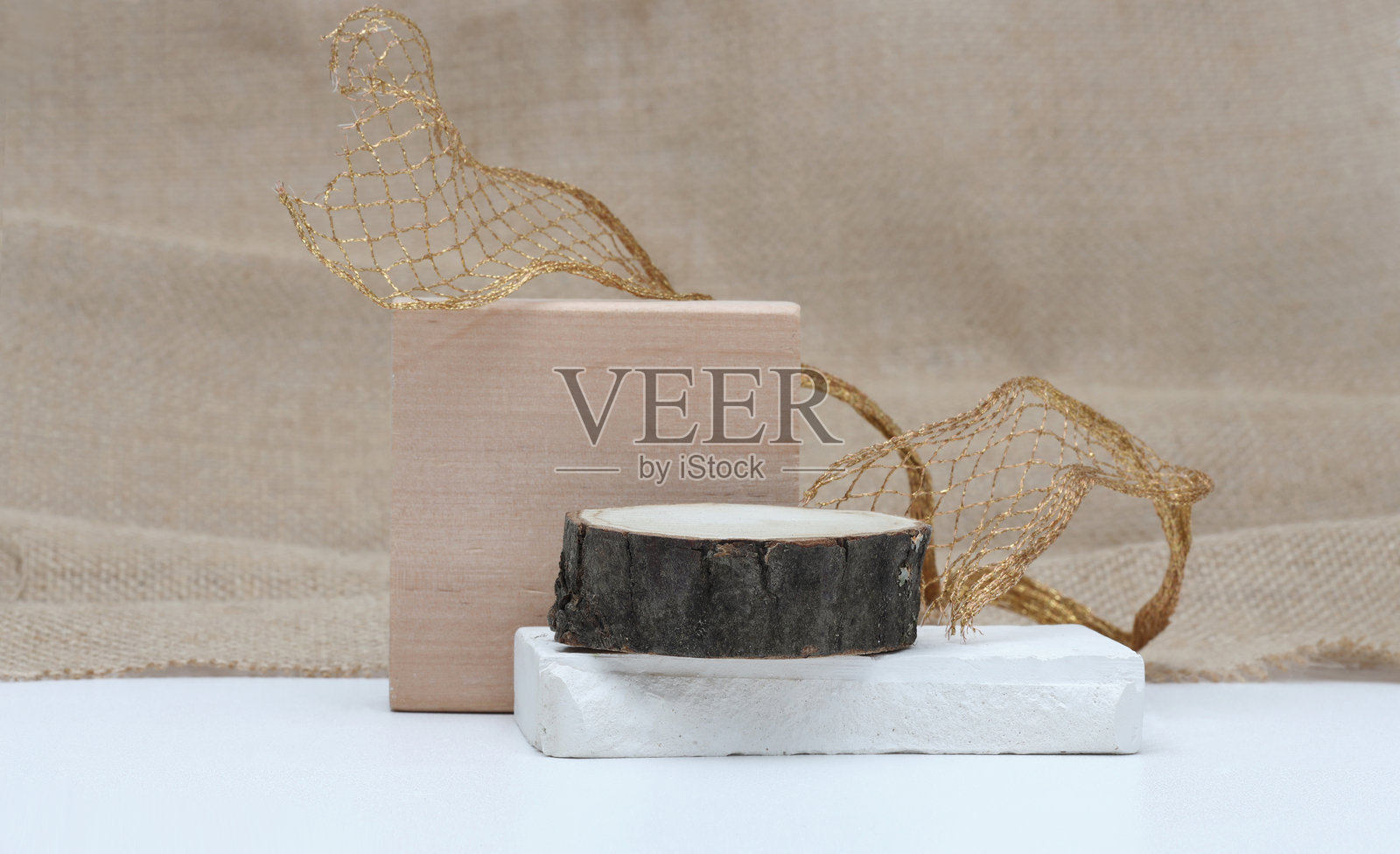 堆叠的石头和木质平台讲台，背景为画布。简约的空旷展示产品的场景。照片摄影图片