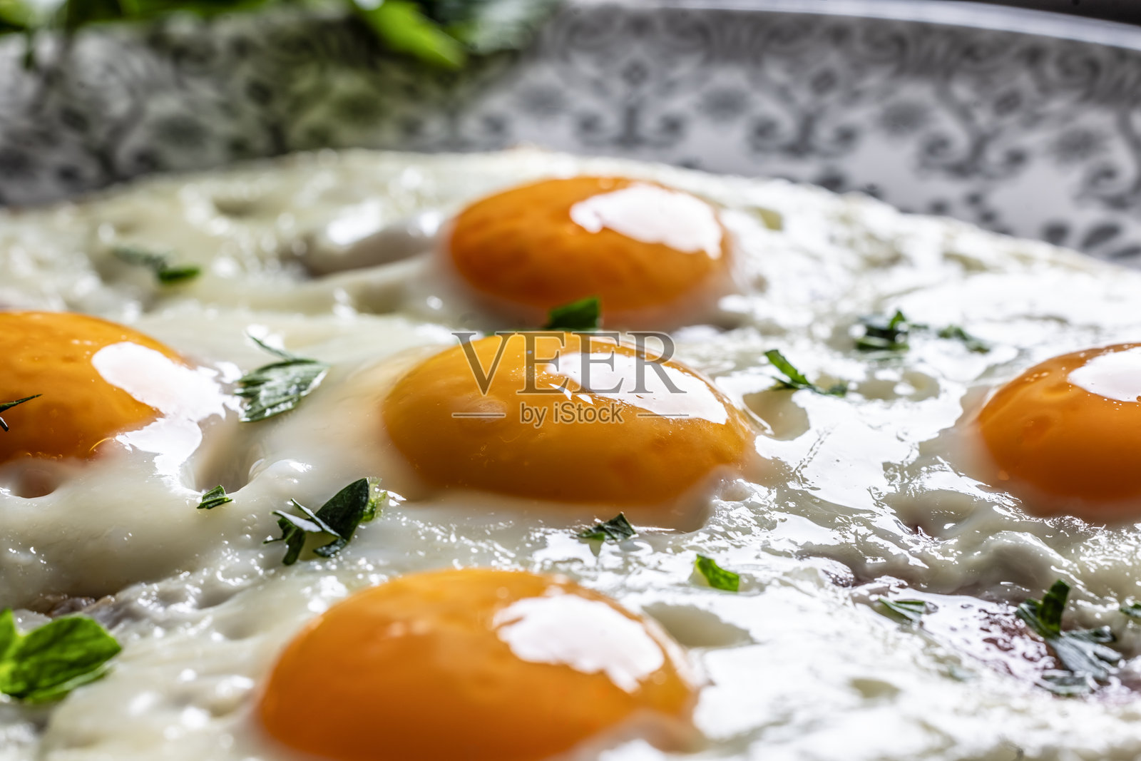 盘子上的英式早餐。火腿和鸡蛋上撒有香菜。照片摄影图片