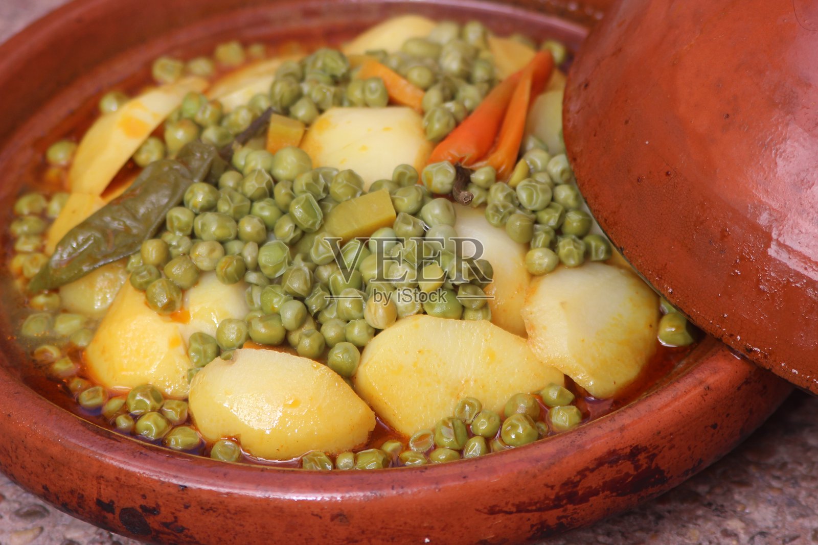 摩洛哥塔吉锅配豌豆和土豆照片摄影图片
