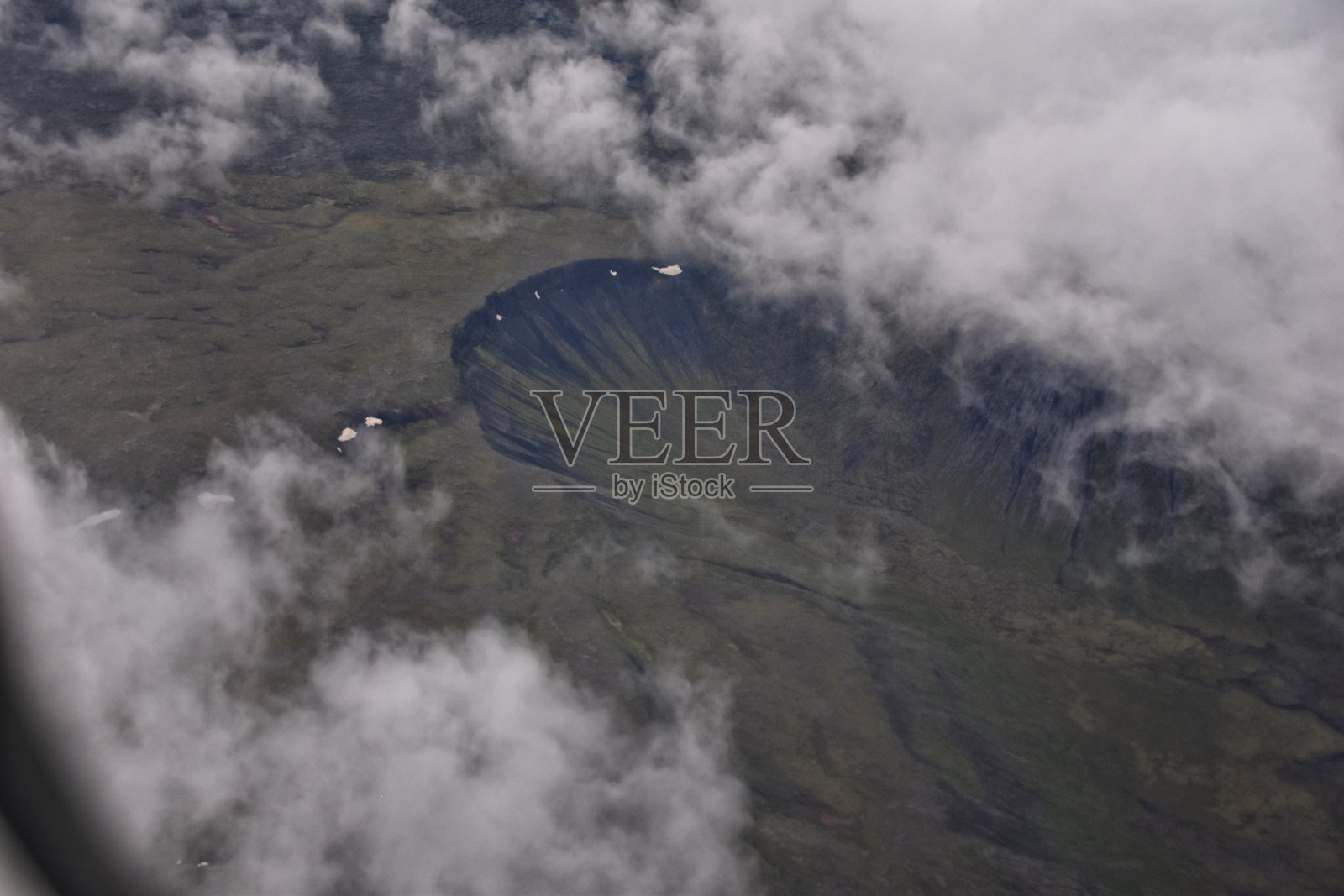 从飞机上透过云层俯瞰冰岛。冰岛风景的空中美景。旅行度假概念。欧洲。照片摄影图片