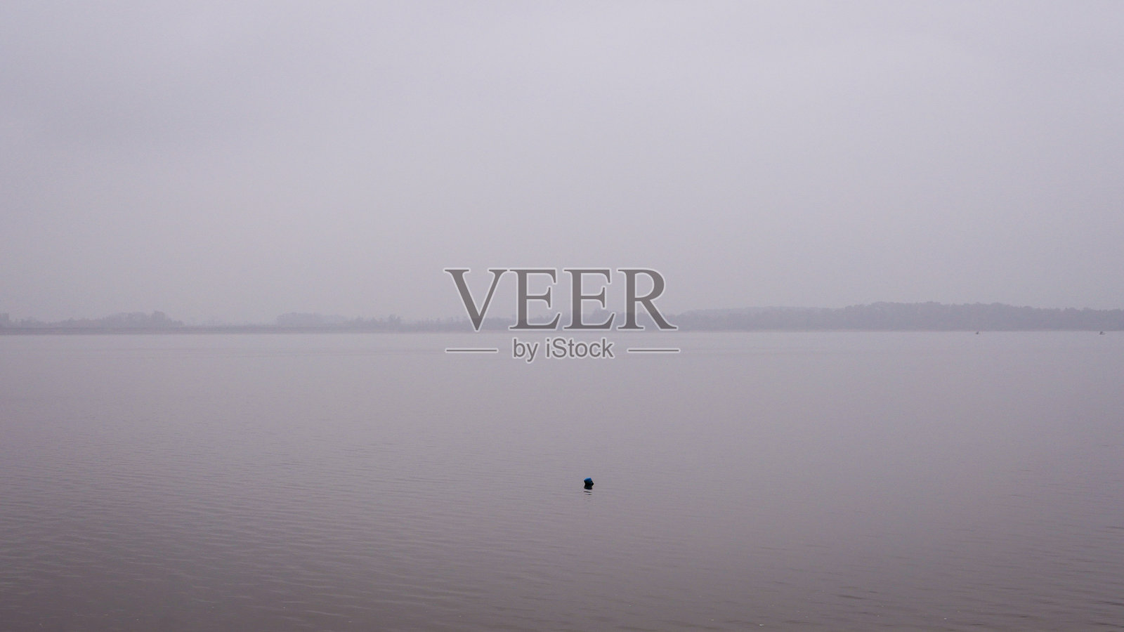 湖面上自然的雾气，远处是森林。照片摄影图片